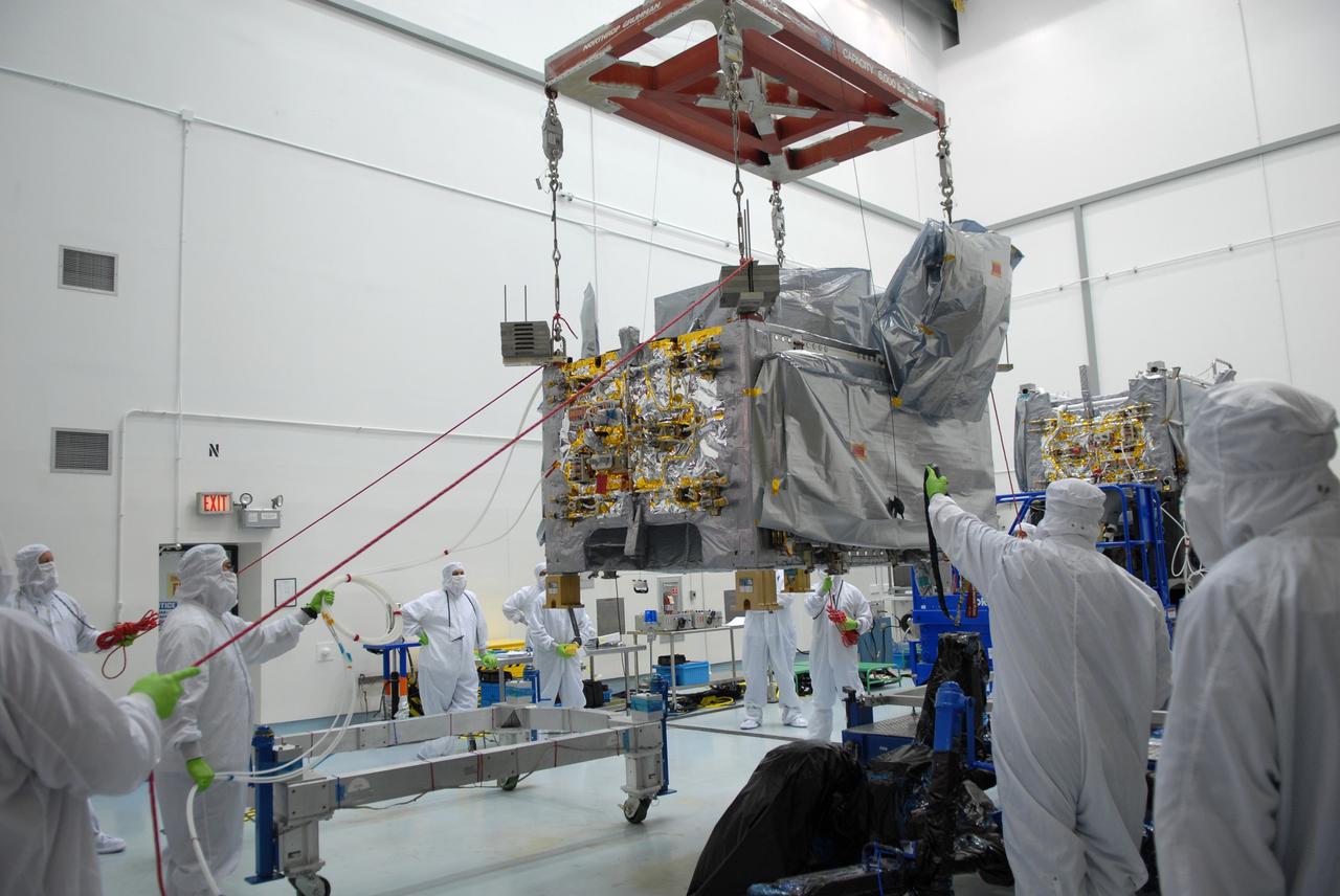 CAPE CANAVERAL, Fla. – At the Astrotech payload processing facility in Titusville, Fla., workers help guide the movement of the SV1 spacecraft as it is moved toward the SV2 behind it.  The two spacecraft are part of the Space Tracking and Surveillance System – Demonstrators, or STSS Demo, Program. The STSS Demo is a space-based sensor component of a layered Ballistic Missile Defense System designed for the overall mission of detecting, tracking and discriminating ballistic missiles.  STSS is capable of tracking objects after boost phase and provides trajectory information to other sensors. It will be launched by NASA for the Missile Defense Agency between 8 and 8:58 a.m. EDT Sept. 18.  Approved for Public Release 09-MDA-04886 (10 SEPT 09) Photo credit: NASA/Jim Grossmann