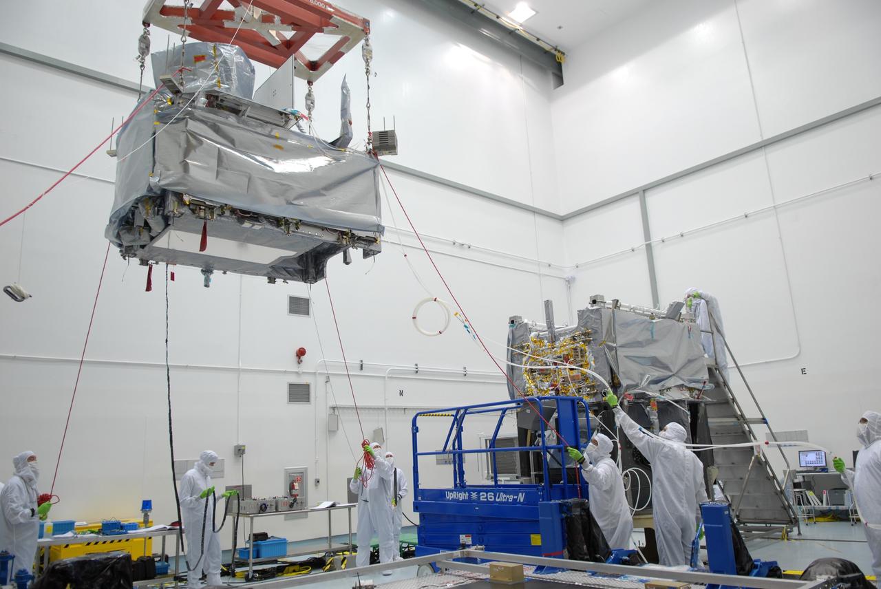 CAPE CANAVERAL, Fla. – At the Astrotech payload processing facility in Titusville, Fla., workers help guide the movement of the SV1 spacecraft as it is moved toward the SV2 at right.  The two spacecraft are part of the Space Tracking and Surveillance System – Demonstrators, or STSS Demo, Program.  The STSS Demo is a space-based sensor component of a layered Ballistic Missile Defense System designed for the overall mission of detecting, tracking and discriminating ballistic missiles.  STSS is capable of tracking objects after boost phase and provides trajectory information to other sensors. It will be launched by NASA for the Missile Defense Agency between 8 and 8:58 a.m. EDT Sept. 18.  Approved for Public Release 09-MDA-04886 (10 SEPT 09) Photo credit: NASA/Jim Grossmann