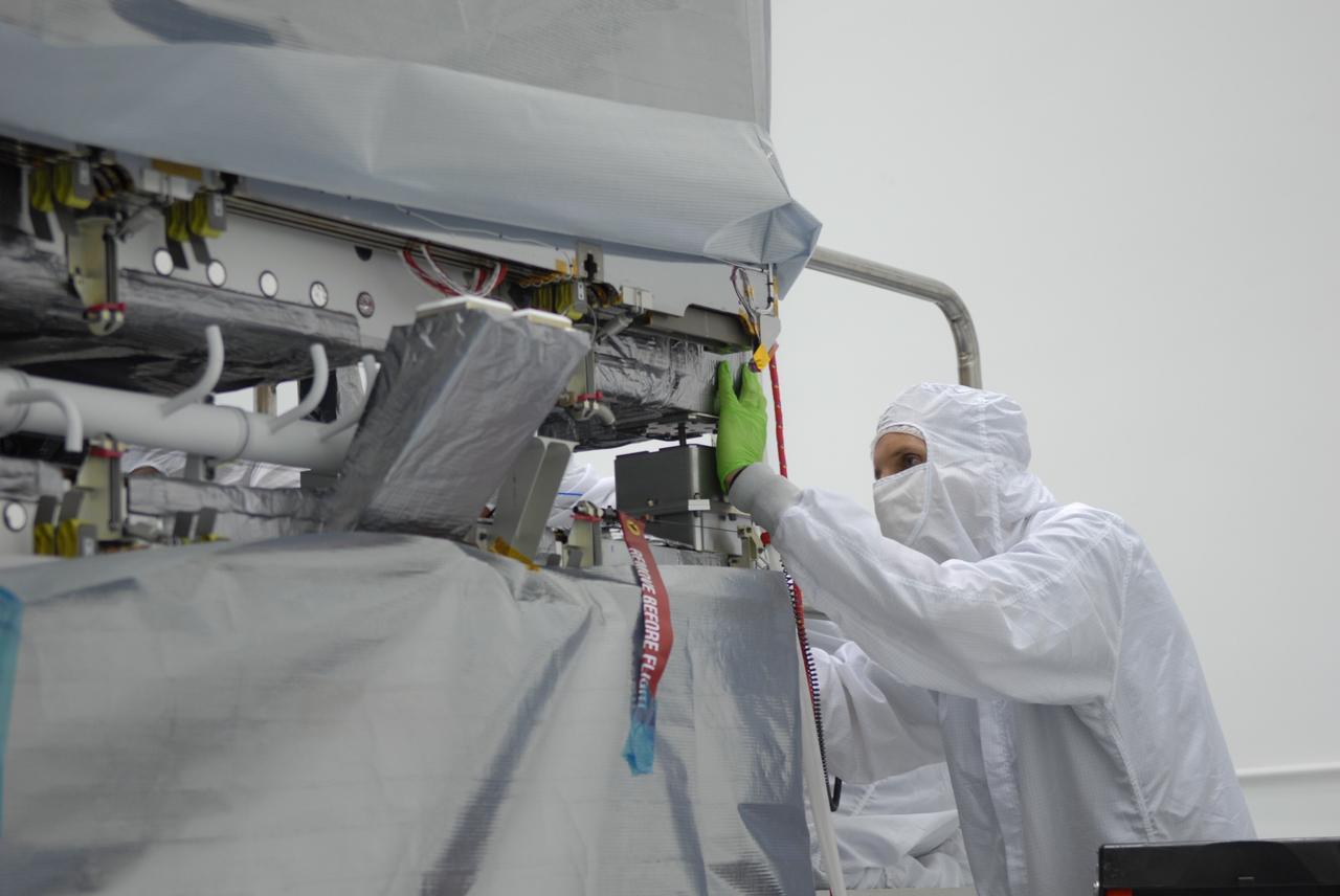 CAPE CANAVERAL, Fla. – At the Astrotech payload processing facility in Titusville, Fla., a worker checks the mating of the SV1 spacecraft onto the SV2. The two spacecraft are part of the Space Tracking and Surveillance System – Demonstrators, or STSS Demo, Program.  The STSS Demo is a space-based sensor component of a layered Ballistic Missile Defense System designed for the overall mission of detecting, tracking and discriminating ballistic missiles.  STSS is capable of tracking objects after boost phase and provides trajectory information to other sensors. It will be launched by NASA for the Missile Defense Agency between 8 and 8:58 a.m. EDT Sept. 18.  Approved for Public Release 09-MDA-04886 (10 SEPT 09) Photo credit: NASA/Jim Grossmann