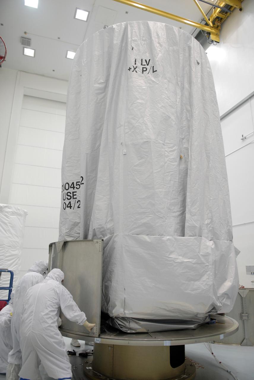 CAPE CANAVERAL, Fla. – At the Astrotech payload processing facility in Titusville, Fla., workers place the first segments of the transportation canister around the base of the Space Tracking and Surveillance System – Demonstrators, or STSS Demo, spacecraft.  The STSS Demo is a space-based sensor component of a layered Ballistic Missile Defense System designed for the overall mission of detecting, tracking and discriminating ballistic missiles.  STSS is capable of tracking objects after boost phase and provides trajectory information to other sensors. It will be launched by NASA for the Missile Defense Agency between 8 and 8:58 a.m. EDT Sept. 18.  Approved for Public Release 09-MDA-04886 (10 SEPT 09) Photo credit: NASA/Kim Shiflett