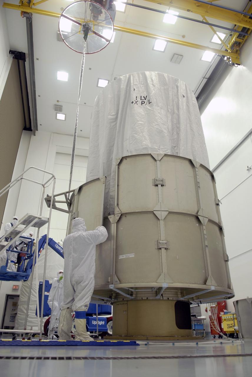 CAPE CANAVERAL, Fla. – At the Astrotech payload processing facility in Titusville, Fla., workers maneuver one of the second-row segments of the transportation canister that will be placed around the Space Tracking and Surveillance System – Demonstrators, or STSS Demo, spacecraft.  The STSS Demo is a space-based sensor component of a layered Ballistic Missile Defense System designed for the overall mission of detecting, tracking and discriminating ballistic missiles.  STSS is capable of tracking objects after boost phase and provides trajectory information to other sensors. It will be launched by NASA for the Missile Defense Agency between 8 and 8:58 a.m. EDT Sept. 18.  Approved for Public Release 09-MDA-04886 (10 SEPT 09) Photo credit: NASA/Kim Shiflett