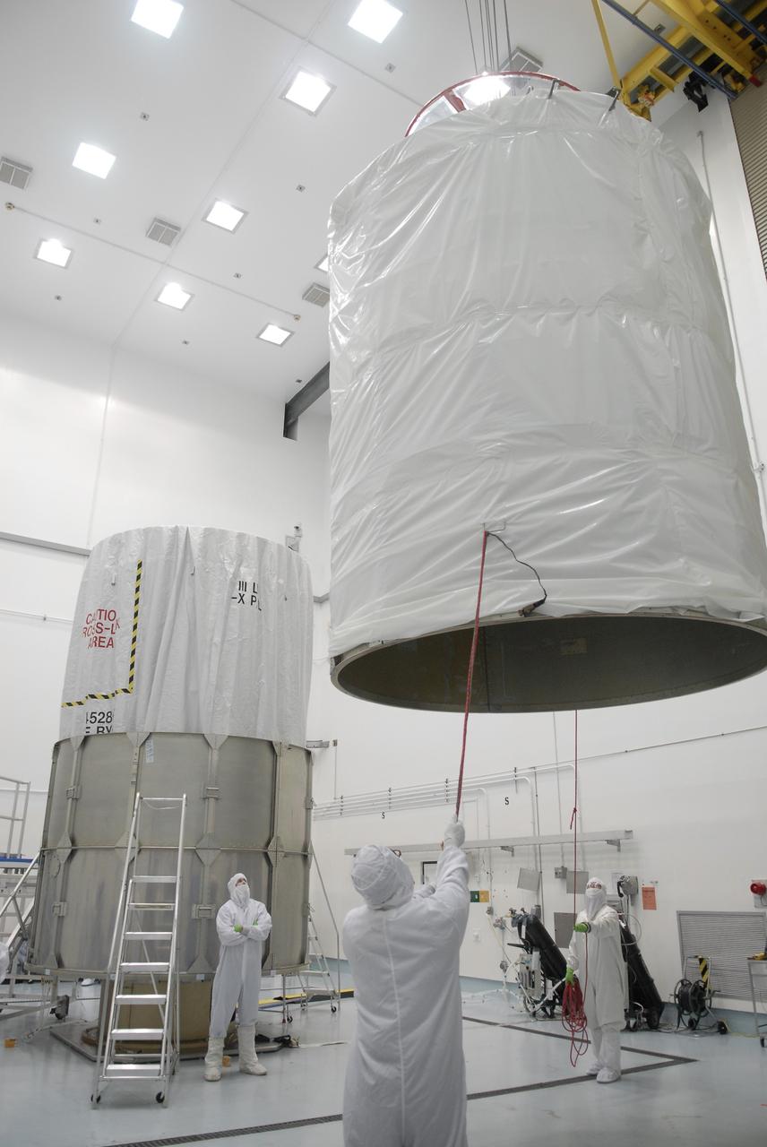 CAPE CANAVERAL, Fla. – At the Astrotech payload processing facility in Titusville, Fla., the upper segment of the transportation canister is moved toward the Space Tracking and Surveillance System – Demonstrators, or STSS Demo, spacecraft, at left. The STSS Demo is a space-based sensor component of a layered Ballistic Missile Defense System designed for the overall mission of detecting, tracking and discriminating ballistic missiles.  STSS is capable of tracking objects after boost phase and provides trajectory information to other sensors. It will be launched by NASA for the Missile Defense Agency between 8 and 8:58 a.m. EDT Sept. 18.  Approved for Public Release 09-MDA-04886 (10 SEPT 09) Photo credit: NASA/Kim Shiflett