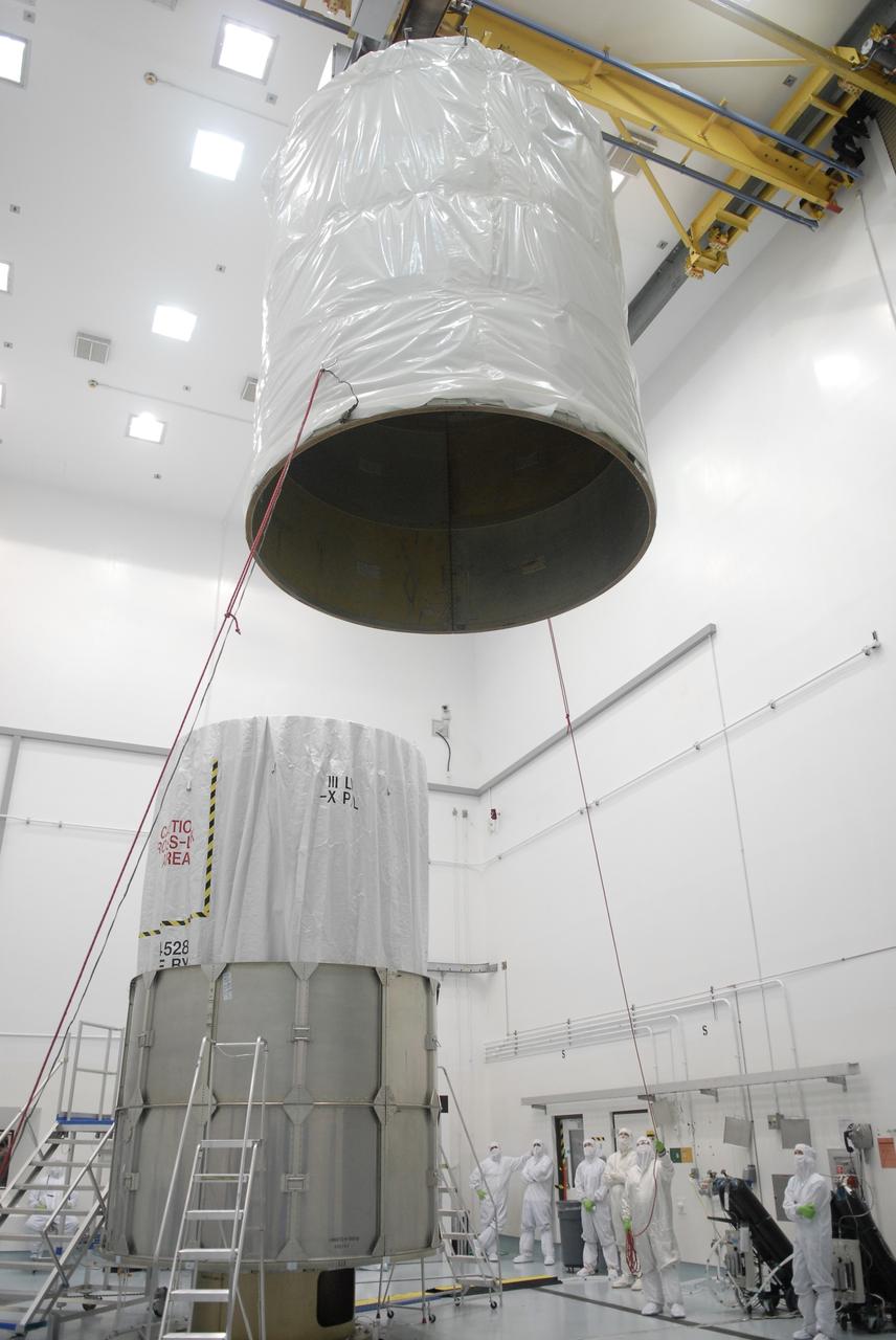 CAPE CANAVERAL, Fla. – At the Astrotech payload processing facility in Titusville, Fla., the upper segment of the transportation canister is moved toward the Space Tracking and Surveillance System – Demonstrators, or STSS Demo, spacecraft, at bottom left.  The STSS Demo is a space-based sensor component of a layered Ballistic Missile Defense System designed for the overall mission of detecting, tracking and discriminating ballistic missiles.  STSS is capable of tracking objects after boost phase and provides trajectory information to other sensors. It will be launched by NASA for the Missile Defense Agency between 8 and 8:58 a.m. EDT Sept. 18.  Approved for Public Release 09-MDA-04886 (10 SEPT 09) Photo credit: NASA/Kim Shiflett