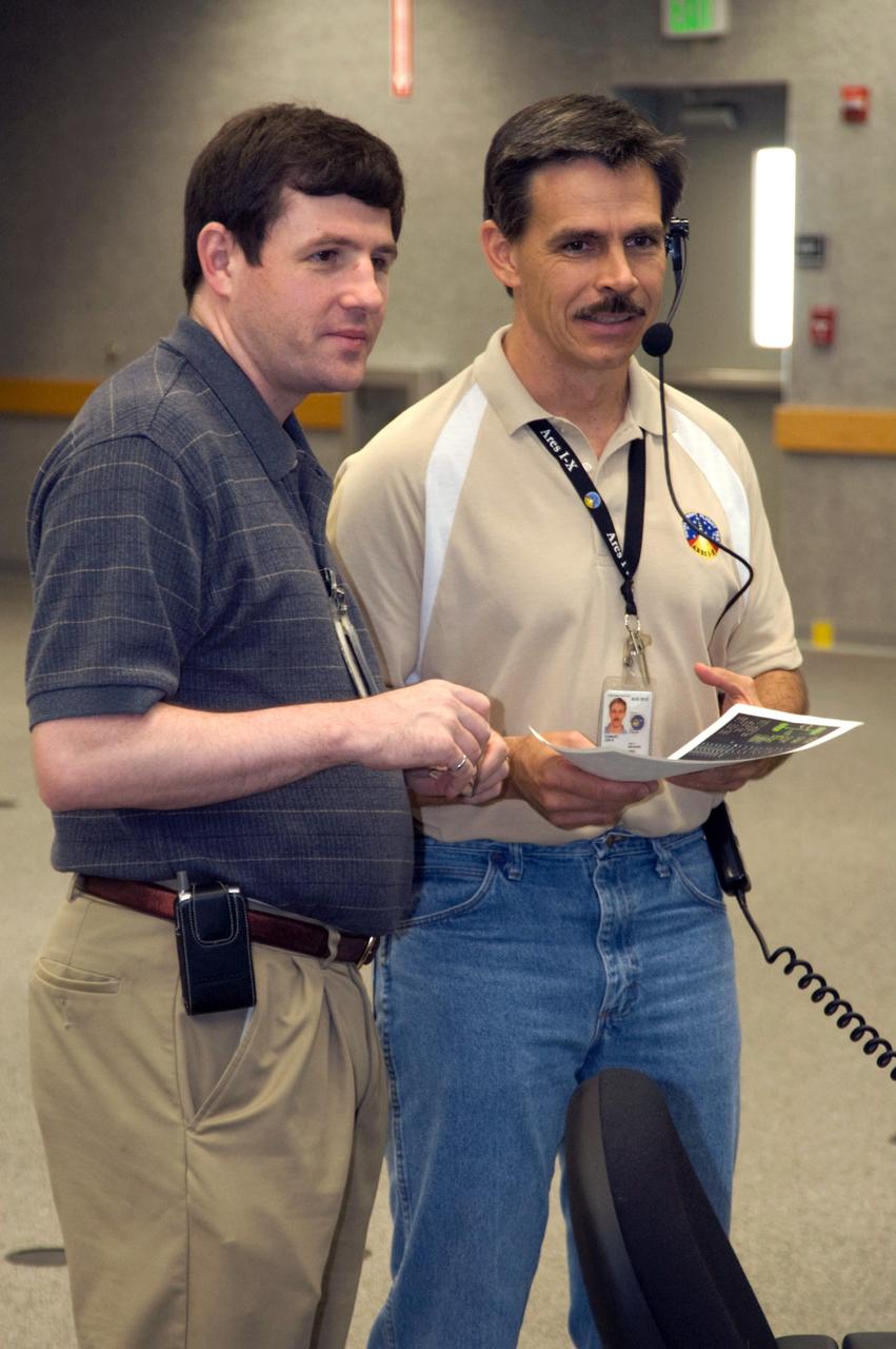 CAPE CANAVERAL, Fla. – In NASA Kennedy Space Center's Launch Control Center, NASA's Ares I-X Avionics IPT Lead Kevin Flynn and Ares I-X deputy mission manager Jon Cowart monitor data in the firing room as the rocket undergoes its first power-up.    Part of the Constellation Program, the Ares I-X is the test vehicle for the Ares I, which is the essential core of a space transportation system that eventually will carry crewed missions back to the moon, on to Mars and out into the solar system. The Ares I-X flight test is targeted for  Oct. 31.  Photo credit: NASA/Cory Huston