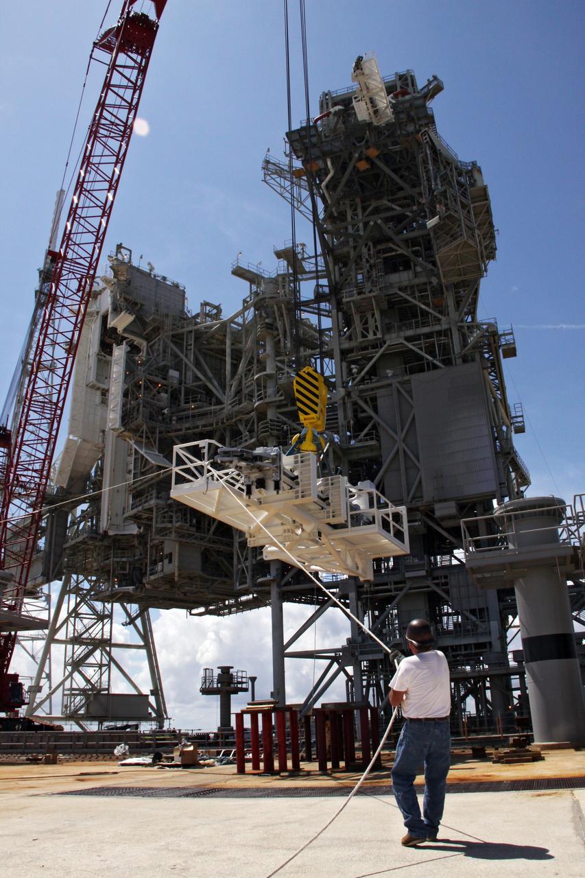 CAPE CANAVERAL, Fla. –  On NASA Kennedy Space Center's Launch Pad 39B, a second stabilizing arm  is lifted for installation at the top of the fixed service structure.  The hardware is being reconfigured for launch of NASA's Ares I-X rocket, part of the agency's Constellation Program.   The Ares I-X flight test is targeted for Oct. 31.  Photo credit: NASA/Troy Cryder