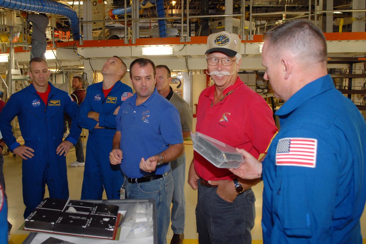 CAPE CANAVERAL, Fla. – In NASA Kennedy Space Center's Orbiter Processing Facility 1, STS-129 crew members look over equipment that is part of the mission.  At left are Commander Charles Hobaugh and Mission Specialist Randy Bresnik; at right is Pilot Barry Wilmore.  The crew is at Kennedy for a Crew Equipment Interface Test, which provides hands-on training and observation of shuttle and flight hardware.  Space shuttle Atlantis' STS-129 mission is targeted to launch Nov. 12.  Photo credit: NASA/Jim Grossmann