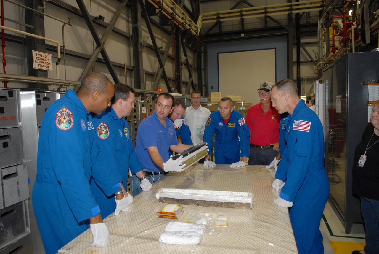 CAPE CANAVERAL, Fla. – In NASA Kennedy Space Center's Orbiter Processing Facility 1, STS-129 crew members look over equipment that is part of the mission.  From left, clockwise, are Mission Specialists Robert Satcher, Michael Foreman, a technician, Pilot Barry Wilmore, Mission Specialists Randy Bresnik and Leland Melvin,  and Commander Charles Hobaugh.  The crew is at Kennedy for a Crew Equipment Interface Test, which provides hands-on training and observation of shuttle and flight hardware.  Space shuttle Atlantis' STS-129 mission is targeted to launch Nov. 12.  Photo credit: NASA/Jim Grossmann
