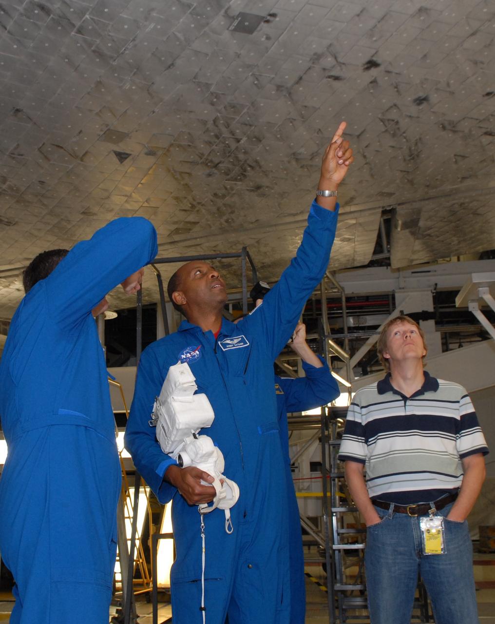 CAPE CANAVERAL, Fla. – In NASA Kennedy Space Center's Orbiter Processing Facility 1, STS-129 Mission Specialists Michael Foreman and Robert Satcher take a close look at some of the tiles on the underside of space shuttle Atlantis. The crew is at Kennedy for a Crew Equipment Interface Test, which provides hands-on training and observation of shuttle and flight hardware. Atlantis' STS-129 mission is targeted to launch Nov. 12. Photo credit: NASA/Jim Grossmann
