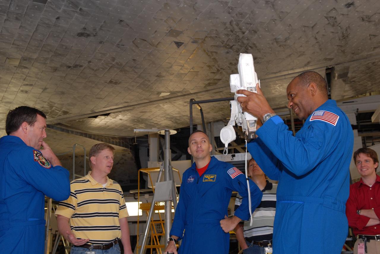 CAPE CANAVERAL, Fla. – -- In NASA Kennedy Space Center's Orbiter Processing Facility 1, STS-129 Mission Specialist Robert Satcher, at right, practices focusing a camera on Mission Specialist Michael Foreman, at left, while Mission Specialist Randy Bresnik, at center, looks on. The camera will be used on the mission. The crew is at Kennedy for a Crew Equipment Interface Test, which provides hands-on training and observation of shuttle and flight hardware. Atlantis' STS-129 mission is targeted to launch Nov. 12. Photo credit: NASA/Jim Grossmann