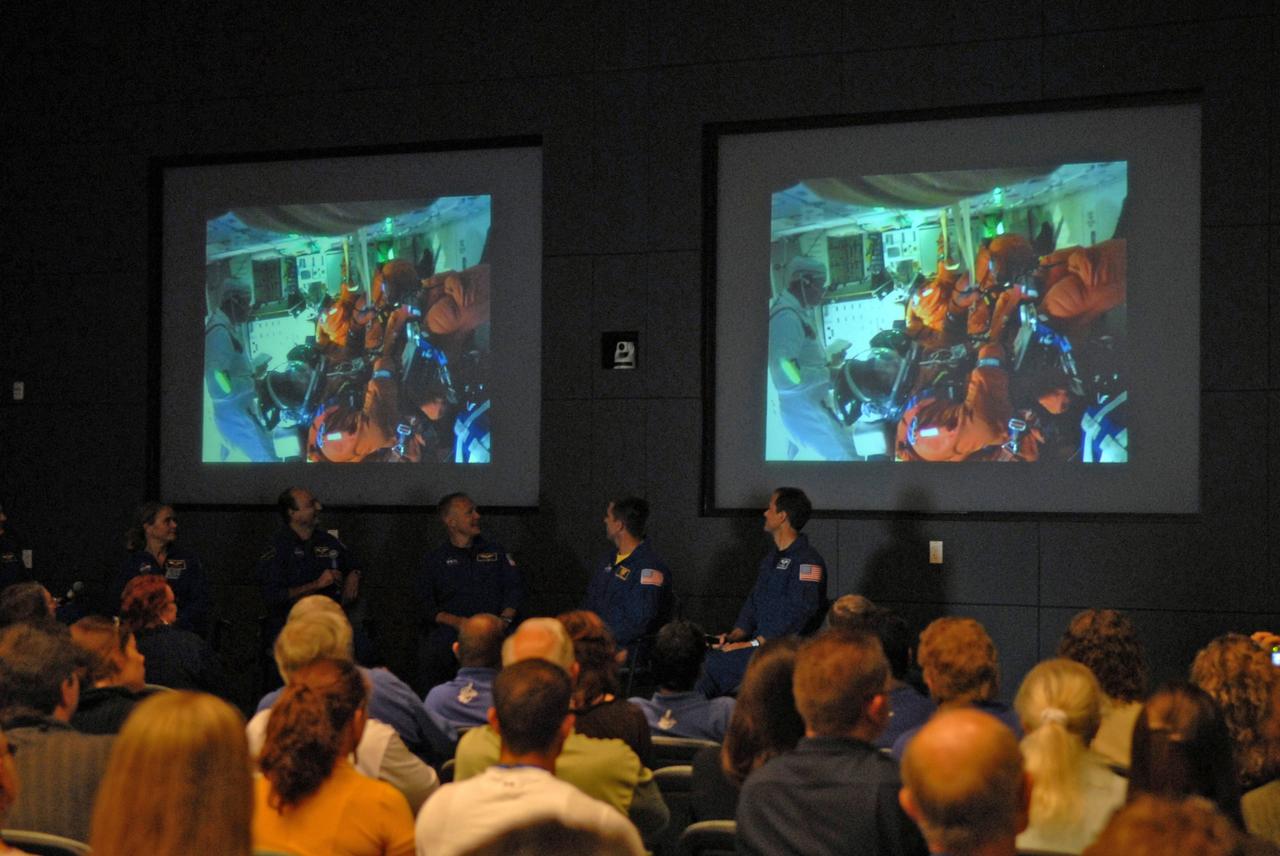 CAPE CANAVERAL, Fla. – Crew members of the STS-127 mission return to NASA's Kennedy Space Center in Florida to share stories, photos and videos of their experiences on the mission.  Seen seated beneath the video screens are Mission Specialist Julie Payette, Commander Mark Polansky, Pilot Doug Hurley, and Mission Specialists Christopher Cassidy and Tom Marshburn.  Not seen at far left is Mission Specialist Dave Wolf.  The STS-127 mission was the final of three flights dedicated to the assembly of the Japanese Kibo laboratory complex on the International Space Station.  The crew launched on space shuttle Endeavour on July 15 and returned July 31.  Photo credit: NASA/Jim Grossmann