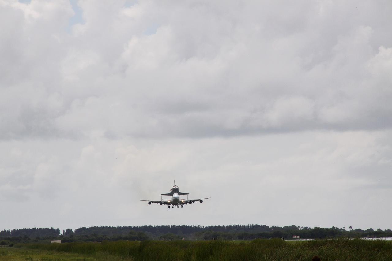 CAPE CANAVERAL, Fla. –  Space shuttle Discovery arrives at NASA's Kennedy Space Center in Florida on the back of the Boeing 747 Shuttle Carrier Aircraft, or SCA.  The two-day return flight from Edwards Air Force Base in California began at 9:20 a.m. EDT Sept. 20.  After three fueling stops that included an overnight stay in Louisiana, the piggybacked shuttle had to navigate through a line of showers across Louisiana and around Kennedy. Discovery had landed at Edwards Sept. 11 after the 13-day STS-128 mission to the International Space Station. The shuttle delivered more than 7 tons of supplies, science racks and equipment, as well as additional environmental hardware to sustain six crew members on the station.  Landings at Kennedy were waved off on two days due to inclement weather, leading to the landing at Edwards.  Photo credit: NASA/Jack Pfaller