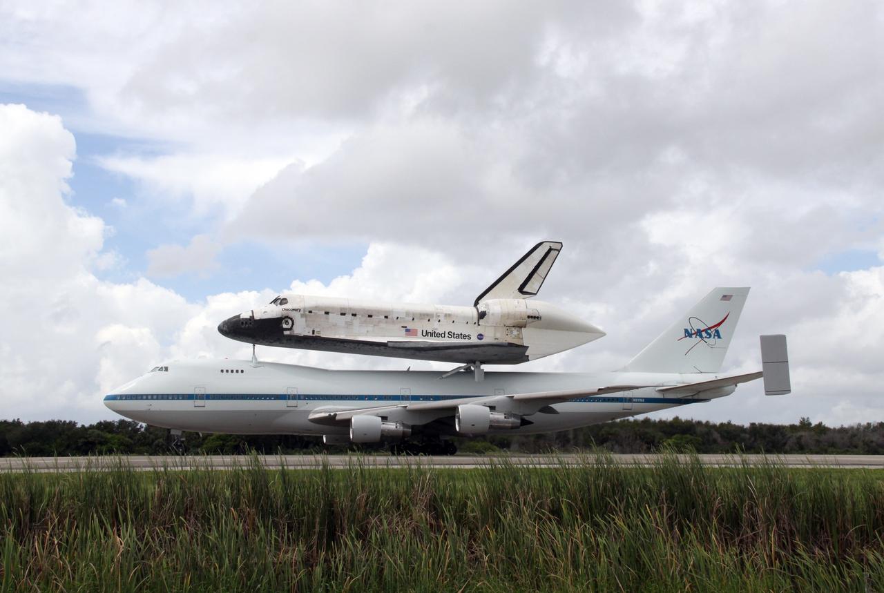 CAPE CANAVERAL, Fla. – The Boeing 747 Shuttle Carrier Aircraft, or SCA, with space shuttle Discovery on top, rolls on runway 33 at NASA's Kennedy Space Center in Florida after touchdown at 12:05 p.m. EDT. The two-day return flight from Edwards Air Force Base in California began at 9:20 a.m. EDT Sept. 20. After three fueling stops that included an overnight stay in Louisiana, the piggybacked shuttle had to navigate through a line of showers across Louisiana and around Kennedy. Discovery had landed at Edwards Sept. 11 after the 13-day STS-128 mission to the International Space Station. The shuttle delivered more than 7 tons of supplies, science racks and equipment, as well as additional environmental hardware to sustain six crew members on the station. Landings at Kennedy were waved off on two days due to inclement weather, leading to the landing at Edwards. Photo credit: NASA/Jack Pfaller