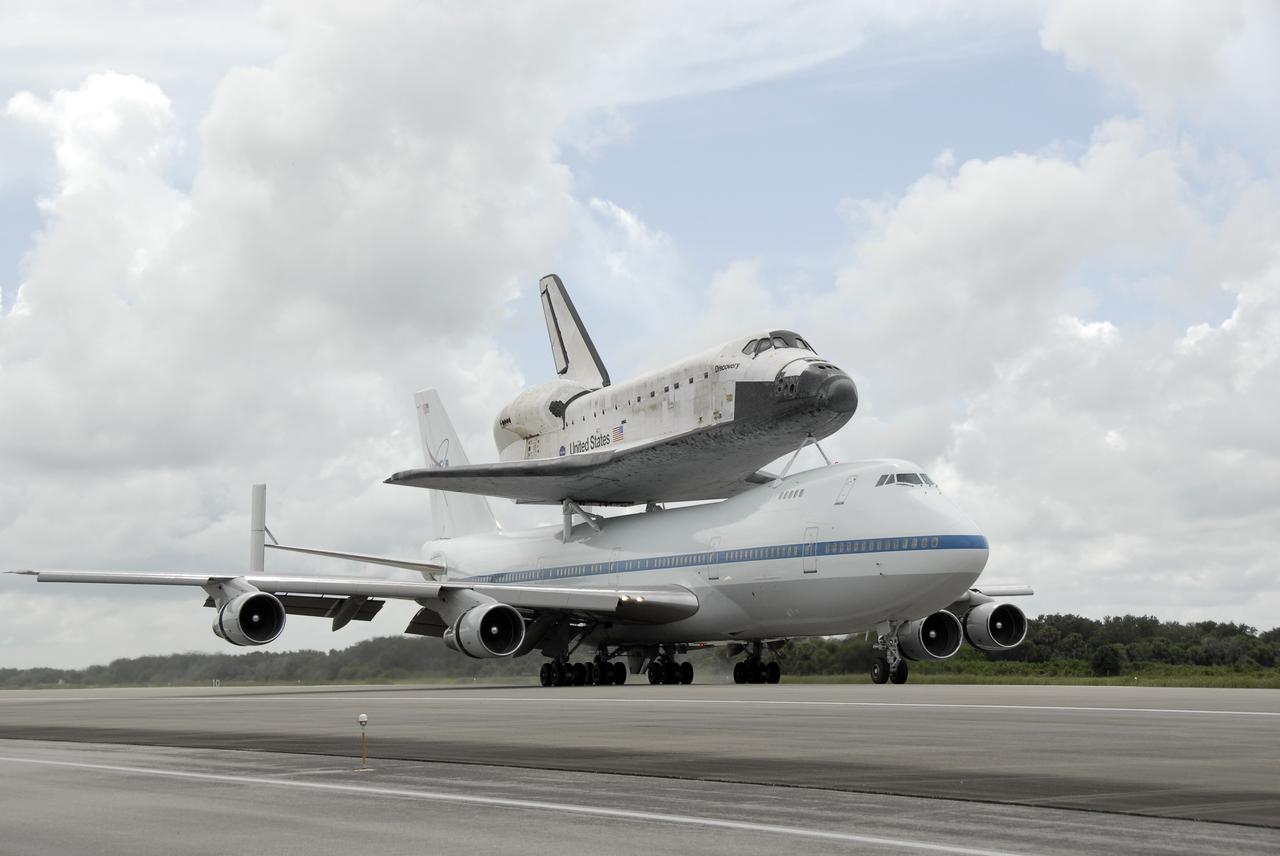 CAPE CANAVERAL, Fla. – The Boeing 747 Shuttle Carrier Aircraft, or SCA, with space shuttle Discovery on top, rolls down the Shuttle Landing Facility's runway 33 at NASA's Kennedy Space Center in Florida after touching down at 12:05 p.m. EDT. The two-day return flight from Edwards Air Force Base in California began at 9:20 a.m. EDT Sept. 20. After three fueling stops that included an overnight stay in Louisiana, the piggybacked shuttle had to navigate through a line of showers across Louisiana and around Kennedy. Discovery had landed at Edwards Sept. 11 after the 13-day STS-128 mission to the International Space Station. The shuttle delivered more than 7 tons of supplies, science racks and equipment, as well as additional environmental hardware to sustain six crew members on the station. Landings at Kennedy were waved off on two days due to inclement weather, leading to the landing at Edwards. Photo credit: NASA/Kim Shiflett
