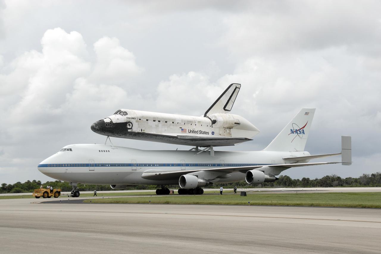 CAPE CANAVERAL, Fla. – The Boeing 747 Shuttle Carrier Aircraft, or SCA, with space shuttle Discovery on top, is ready for towing from the Shuttle Landing Facility's runway 33 at NASA's Kennedy Space Center in Florida after touching down at 12:05 p.m. EDT. The two-day return flight from Edwards Air Force Base in California began at 9:20 a.m. EDT Sept. 20. After three fueling stops that included an overnight stay in Louisiana, the piggybacked shuttle had to navigate through a line of showers across Louisiana and around Kennedy. Discovery had landed at Edwards Sept. 11 after the 13-day STS-128 mission to the International Space Station. The shuttle delivered more than 7 tons of supplies, science racks and equipment, as well as additional environmental hardware to sustain six crew members on the station. Landings at Kennedy were waved off on two days due to inclement weather, leading to the landing at Edwards. Photo credit: NASA/Kim Shiflett