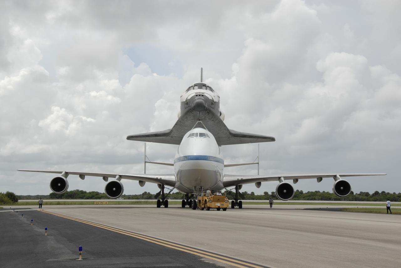 CAPE CANAVERAL, Fla. –  The Boeing 747 Shuttle Carrier Aircraft, or SCA, with space shuttle Discovery on top, is towed from the Shuttle Landing Facility's runway 33 at NASA's Kennedy Space Center in Florida after touching down at 12:05 p.m. EDT.   The two-day return flight from Edwards Air Force Base in California began at 9:20 a.m. EDT Sept. 20.  After three fueling stops that included an overnight stay in Louisiana, the piggybacked shuttle had to navigate through a line of showers across Louisiana and around Kennedy. Discovery had landed at Edwards Sept. 11 after the 13-day STS-128 mission to the International Space Station. The shuttle delivered more than 7 tons of supplies, science racks and equipment, as well as additional environmental hardware to sustain six crew members on the station.  Landings at Kennedy were waved off on two days due to inclement weather, leading to the landing at Edwards.  Photo credit: NASA/Kim Shiflett