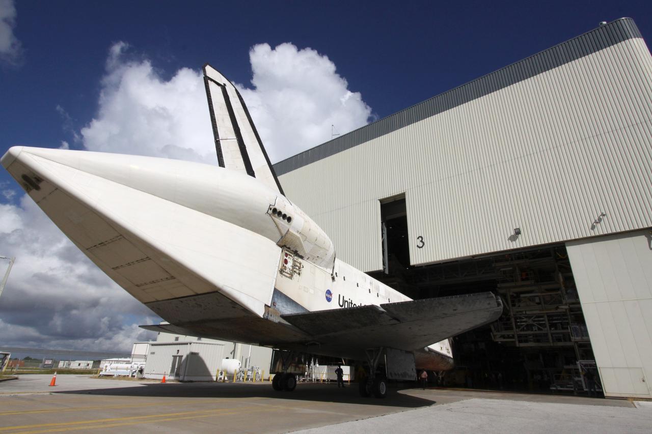 CAPE CANAVERAL, Fla. – Space shuttle Discovery is towed through the open doors of NASA Kennedy Space Center's Orbiter Processing Facility 3. In the OPF, turnaround processing procedures on Discovery will include various post-flight deservicing and maintenance functions, which are carried out in parallel with payload removal and the installation of equipment needed for the next mission. Discovery returned to Kennedy atop a Shuttle Carrier Aircraft Sept. 21 after a two-day ferry flight. The piggybacked shuttle and aircraft touched down on the Shuttle Landing Facility's runway 33 at 12:05 p.m. EDT and the shuttle later was demated from the aircraft. Discovery landed at Edwards Air Force Base in California on Sept. 11 after the 13-day STS-128 mission to the International Space Station. Landings at Kennedy were waved off on two days due to inclement weather, leading to the landing at Edwards. Photo credit: NASA/Jack Pfaller