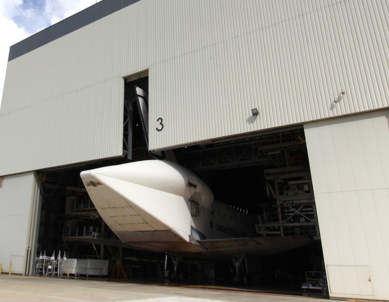 CAPE CANAVERAL, Fla. – Space shuttle Discovery rolls into NASA Kennedy Space Center's Orbiter Processing Facility 3. In the OPF, turnaround processing procedures on Discovery will include various post-flight deservicing and maintenance functions, which are carried out in parallel with payload removal and the installation of equipment needed for the next mission. Discovery returned to Kennedy atop a Shuttle Carrier Aircraft Sept. 21 after a two-day ferry flight. The piggybacked shuttle and aircraft touched down on the Shuttle Landing Facility's runway 33 at 12:05 p.m. EDT and the shuttle later was demated from the aircraft. Discovery landed at Edwards Air Force Base in California on Sept. 11 after the 13-day STS-128 mission to the International Space Station. Landings at Kennedy were waved off on two days due to inclement weather, leading to the landing at Edwards. Photo credit: NASA/Jack Pfaller