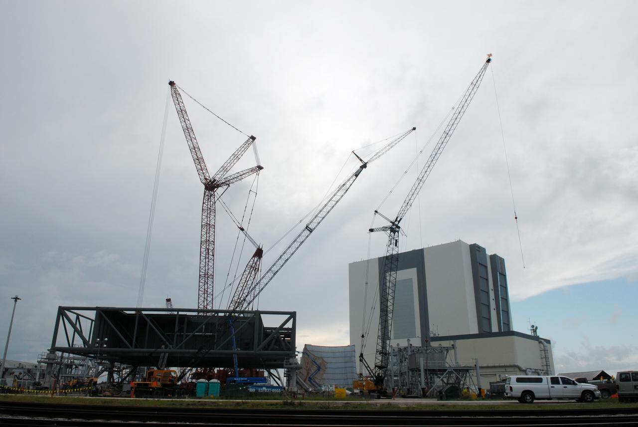 CAPE CANAVERAL, Fla. – Huge cranes are employed in building the new mobile launcher behind NASA Kennedy Space Center's Vehicle Assembly Building for the Constellation Program's Ares rockets. The ML will be the base to launch the Orion crew exploration vehicle and the cargo vehicle. The base is being made lighter than space shuttle mobile launcher platforms so the crawler-transporter can pick up the added load of the 345-foot tower and taller rocket. When the structural portion of the new mobile launcher is complete, umbilicals, access arms, communications equipment and command/control equipment will be installed. Photo credit: NASA/Jim Grossmann