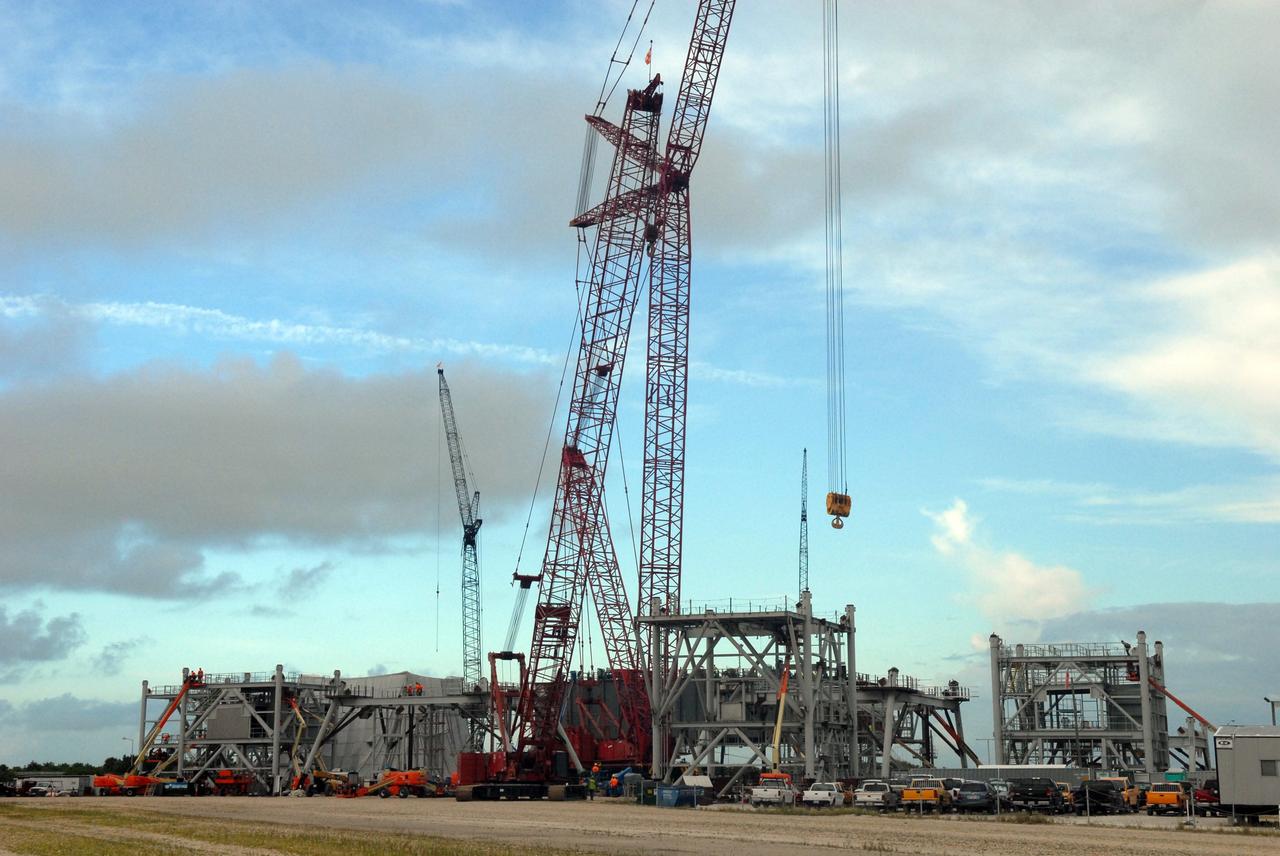 CAPE CANAVERAL, Fla. – Huge cranes are employed in building the new mobile launcher behind NASA Kennedy Space Center's Vehicle Assembly Building for the Constellation Program's Ares rockets. The ML will be the base to launch the Orion crew exploration vehicle and the cargo vehicle. The base is being made lighter than space shuttle mobile launcher platforms so the crawler-transporter can pick up the added load of the 345-foot tower and taller rocket. When the structural portion of the new mobile launcher is complete, umbilicals, access arms, communications equipment and command/control equipment will be installed. Photo credit: NASA/Jim Grossmann
