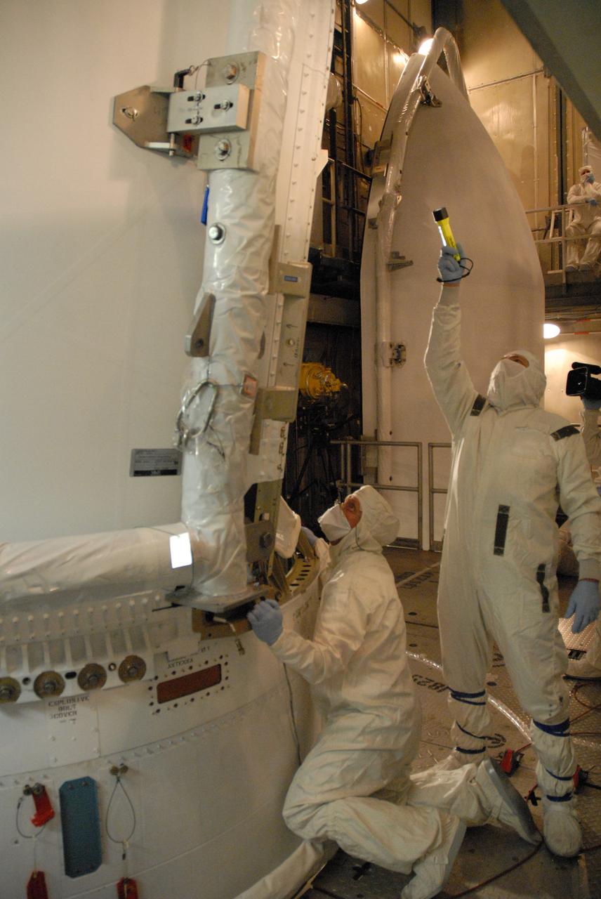 CAPE CANAVERAL, Fla. – Inside the mobile service tower on Launch Pad 17-B at Cape Canaveral Air Force Station in Florida, workers check the fit of the first half of the fairing around the Space Tracking and Surveillance System – Demonstrator spacecraft. The fairing is a two-part molded structure that fits flush with the outside surface of the rocket and forms an aerodynamically smooth nose cone, protecting the spacecraft during launch and ascent.  STSS Demo is a space-based sensor component of a layered Ballistic Missile Defense System designed for the overall mission of detection, tracking and discriminating ballistic missiles.  STSS is capable of tracking objects after boost phase and provides trajectory information to other sensors. It will be launched by NASA for the Missile Defense Agency between 8 and 8:58 a.m. EDT Sept. 18. Approved for Public Release 09-MDA-4934 (09-22-09) Photo credit: NASA/Cory Huston