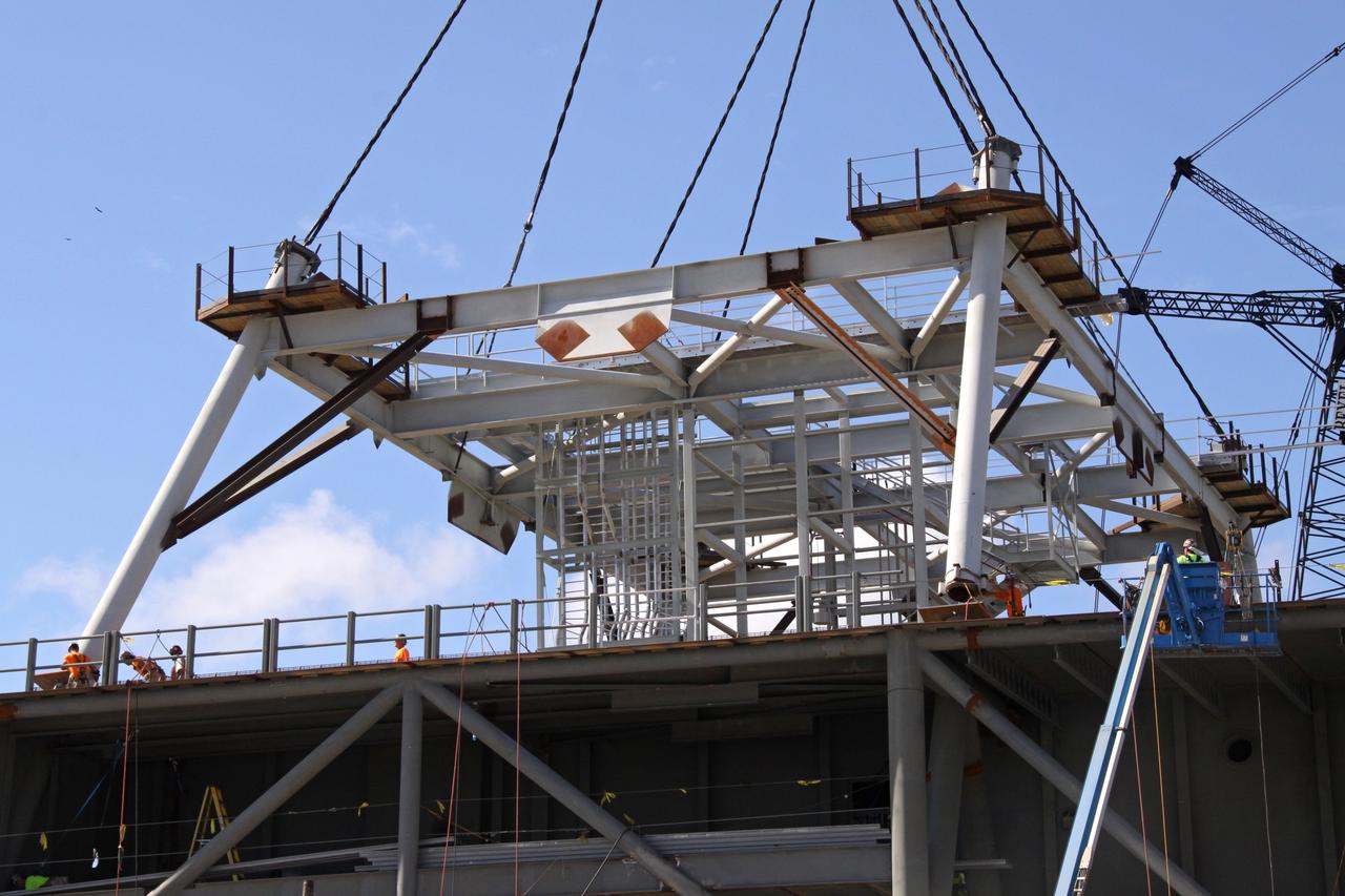 CAPE CANAVERAL, Fla. – Progress is evident in the Constellation Program at NASA's Kennedy Space Center in Florida, as workers install the first section of a tower onto a new mobile launcher, or ML.    The tower of the mobile launcher will have multiple platforms for personnel access and will be approximately 345 feet tall. The launcher is being built at the mobile launcher park site area located north of Kennedy's Vehicle Assembly Building to support the Ares I rocket. The ML will provide a base to launch the Ares I which will transport the Orion crew exploration vehicle, its crew and cargo to low Earth orbit. The base is being made lighter than space shuttle mobile launcher platforms so the crawler-transporter can pick up the heavier load of the tower and taller rocket.  Photo credit: NASA/Jack Pfaller