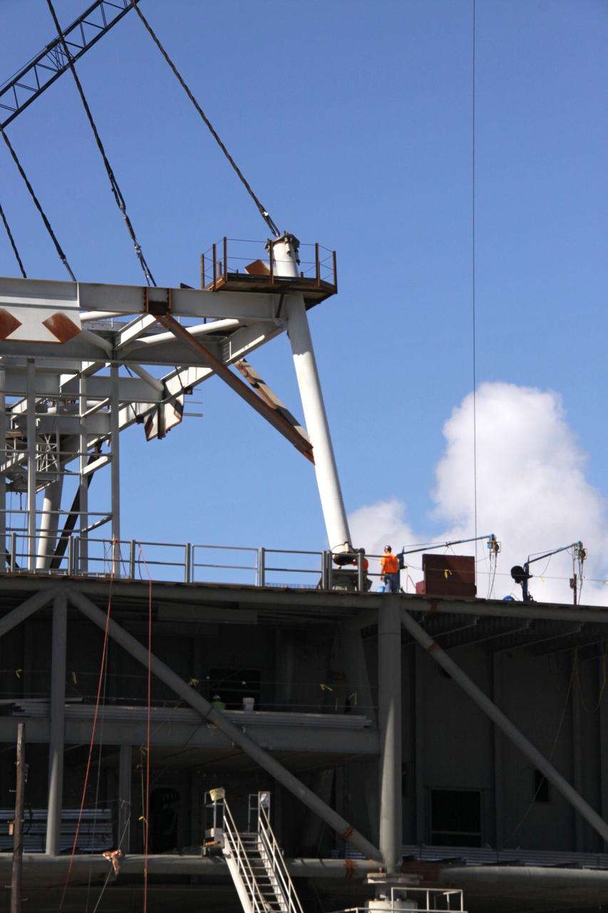 CAPE CANAVERAL, Fla. – Progress is evident in the Constellation Program at NASA's Kennedy Space Center in Florida, as workers position the first section of a tower onto a new mobile launcher, or ML.    The tower of the mobile launcher will have multiple platforms for personnel access and will be approximately 345 feet tall. The launcher is being built at the mobile launcher park site area located north of Kennedy's Vehicle Assembly Building to support the Ares I rocket. The ML will provide a base to launch the Ares I which will transport the Orion crew exploration vehicle, its crew and cargo to low Earth orbit. The base is being made lighter than space shuttle mobile launcher platforms so the crawler-transporter can pick up the heavier load of the tower and taller rocket.  Photo credit: NASA/Jack Pfaller
