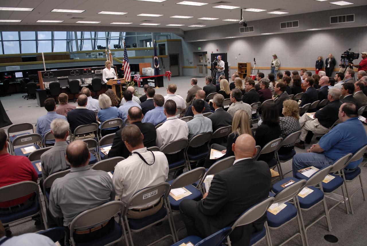 CAPE CANAVERAL, Fla. –  Deputy director of Center Operations at NASA's Kennedy Space Center in Florida Nancy Bray provides some history of the Launch Control Center's Firing Room 1 during a ceremony turning over the facility from the Space Shuttle Program to the Constellation Program at Kennedy.  The room has undergone demolition and construction and been outfitted with consoles for the upcoming Ares I-X rocket flight test targeted for launch on Oct. 27. As the center of launch operations at Kennedy since the Apollo Program, the Launch Control Center, or LCC, has played a central role in NASA's human spaceflight programs. Firing Room 1 was the first operational firing room constructed. From this room, controllers launched the first Saturn V, the first crewed flight of Saturn V, the first crewed mission to the moon and the first space shuttle. Firing Room 1 will continue this tradition of firsts when controllers launch the Constellation Program's first flight test. Also, this firing room will be the center of operations for the upcoming Ares I and Orion operations. Photo credit: NASA/Kim Shiflett