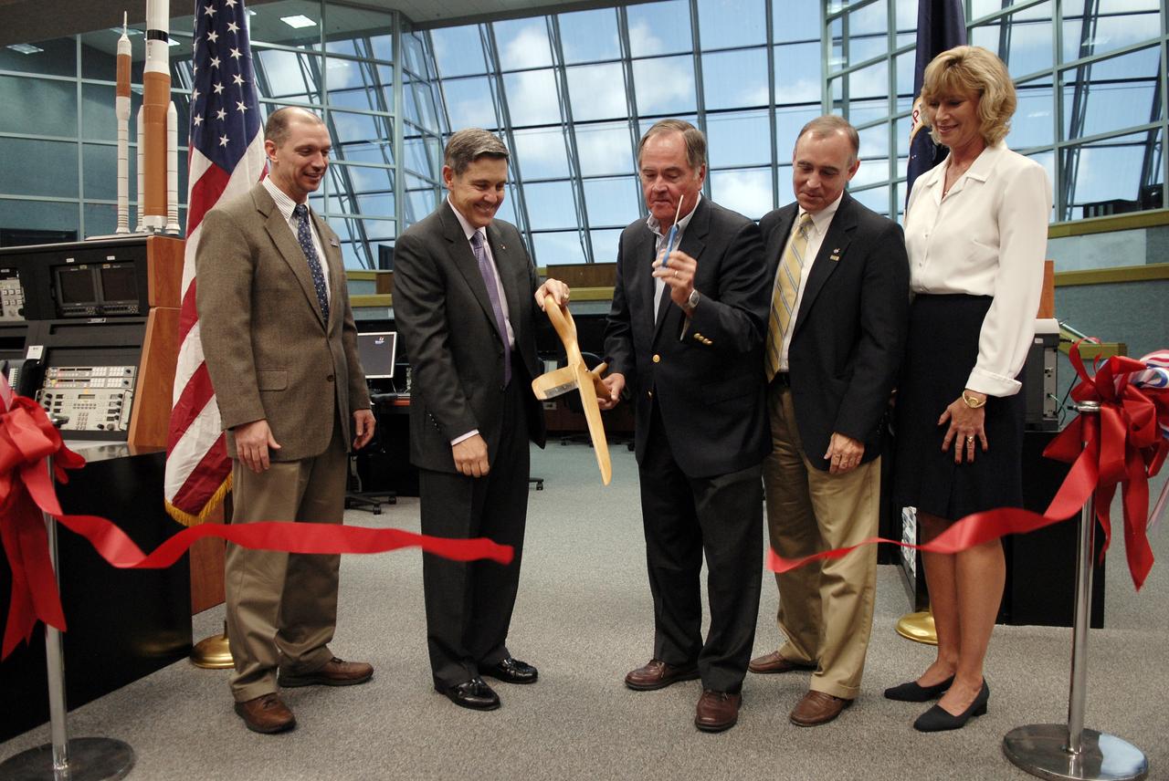 CAPE CANAVERAL, Fla. –  This ribbon cutting officially turns over NASA Kennedy Space Center's Launch Control Center Firing Room 1 from the Space Shuttle Program to the Constellation Program.  Participating are (from left) Pepper Phillips, director of the Constellation Project Office at Kennedy; Bob Cabana, Kennedy's director; Robert Crippen, former astronaut; Jeff Hanley, manager of the Constellation Program at NASA's Johnson Space Center; and Nancy Bray, deputy director of Center Operations at Kennedy. The room has undergone demolition and construction and been outfitted with consoles for the upcoming Ares I-X rocket flight test targeted for launch on Oct. 27. As the center of launch operations at Kennedy since the Apollo Program, the Launch Control Center, or LCC, has played a central role in NASA's human spaceflight programs. Firing Room 1 was the first operational firing room constructed. From this room, controllers launched the first Saturn V, the first crewed flight of Saturn V, the first crewed mission to the moon and the first space shuttle. Firing Room 1 will continue this tradition of firsts when controllers launch the Constellation Program's first flight test. Also, this firing room will be the center of operations for the upcoming Ares I and Orion operations. Photo credit: NASA/Kim Shiflett