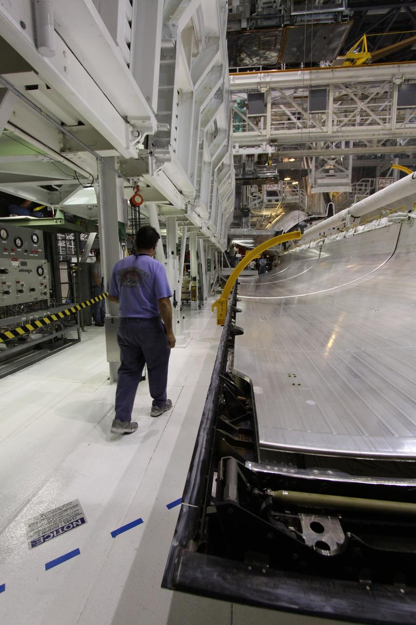 CAPE CANAVERAL, Fla. –  In Orbiter Processing Facility 1 at NASA's Kennedy Space Center in Florida,  a worker walks past space shuttle Atlantis' payload bay doors as they are being closed.   The designated shuttle for the STS-129 mission, Atlantis will deliver to the International Space Station two spare gyroscopes, two nitrogen tank assemblies, two pump modules, an ammonia tank assembly and a spare latching end effector for the station's robotic arm. Atlantis is targeted to launch Nov. 12. Photo credit: NASA/Jack Pfaller