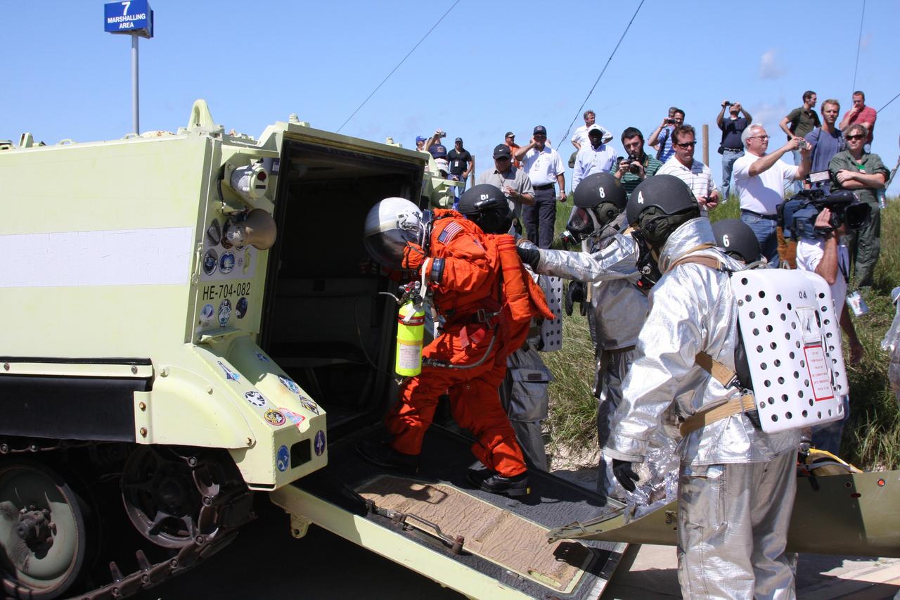 CAPE CANAVERAL, Fla. –  At the Launch Pad 39A slidewire basket landing site at NASA's Kennedy Space Center in Florida, a Mode II-IV exercise is underway, involving NASA fire rescue personnel, volunteers portraying astronauts with simulated injuries, helicopters and personnel from the Air Force’s 920th Rescue Wing and medical trauma teams at three central Florida hospitals.  Here, participants move into an M-113 armored personnel vehicle for transport from the pad.  The drill allows teams to practice an emergency response at Pad 39A, including helicopter evacuation to local hospitals. The Space Shuttle Program and U.S. Air Force are conducting the emergency simulation.  Photo credit: NASA/Dimitri Gerondidakis