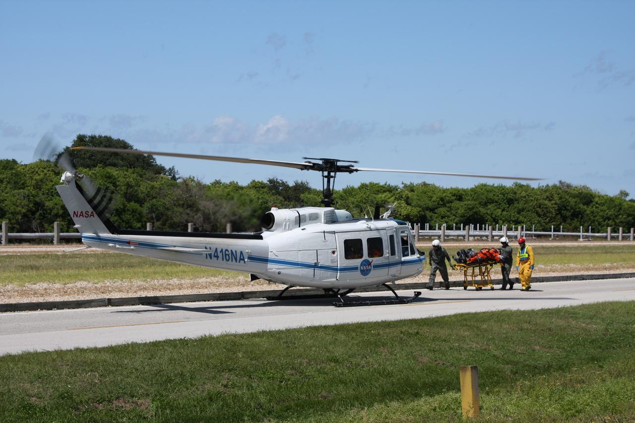 CAPE CANAVERAL, Fla. –  At NASA's Kennedy Space Center in Florida, a Mode II-IV exercise is underway at Launch Pad 39A, involving NASA fire rescue personnel, volunteers portraying astronauts with simulated injuries, helicopters and personnel from the Air Force’s 920th Rescue Wing and medical trauma teams at three central Florida hospitals. Here a participant is taken to a waiting helicopter.  The drill allows teams to practice an emergency response at Pad 39A, including helicopter evacuation to local hospitals. The Space Shuttle Program and U.S. Air Force are conducting the emergency simulation.  Photo credit: NASA/Dimitri Gerondidakis