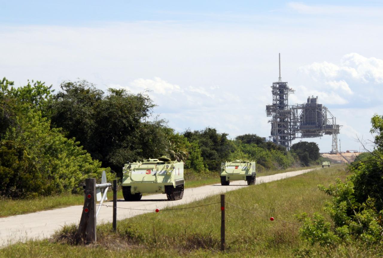 CAPE CANAVERAL, Fla. – At NASA Kennedy Space Center's Launch Pad 39A, M-113 armored personnel carriers exit the area during a Mode II-IV exercise that allows teams to practice an emergency response, including helicopter evacuation to local hospitals. The personnel carriers would be used to transport shuttle crews and responders during an emergency. The exercise involves NASA fire rescue personnel, volunteers portraying astronauts with simulated injuries, helicopters and personnel from the Air Force’s 920th Rescue Wing and medical trauma teams at three central Florida hospitals. The Space Shuttle Program and U.S. Air Force are conducting the emergency simulation. Photo credit: NASA/Jack Pfaller
