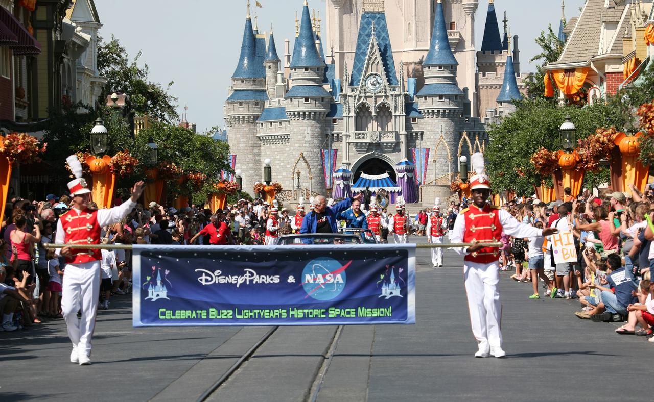 CAPE CANAVERAL, Fla. – At Walt Disney World's Magic Kingdom in Orlando, Fla., a ticker-tape parade officially welcomes toy space ranger Buzz Lightyear home from space.  NASA Apollo 11 astronaut Buzz Aldrin, behind the banner, and International Space Station commander Mike Fincke are featured in the procession.    The 12-inch-tall action figure spent more than 15 months aboard the International Space Station and returned to Earth aboard space shuttle Discovery on Sept. 11 with the STS-128 crew.  Lightyear's space adventure, a collaboration between NASA and Disney Parks, is intended to share the excitement of space exploration with students around the world and encourage them to pursue studies in science, technology, engineering and mathematics.  For additional information, visit http://www.nasa.gov/buzzoniss.  Photo credit: NASA/Dimitri Gerondidakis