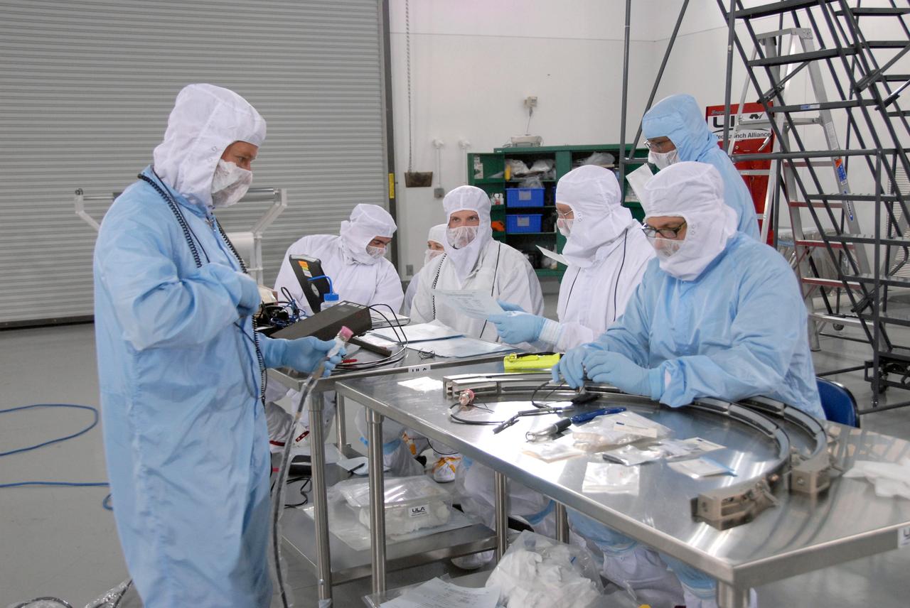 VANDENBERG AIR FORCE BASE, Calif. -- At the Astrotech processing facility on Vandenberg Air Force Base in California, workers prepare a payload adapter ring for NASA's Wide-field Infrared Survey Explorer, or WISE, in preparation for mating to its Payload Attach Fitting.    The satellite will survey the entire sky at infrared wavelengths, creating a cosmic clearinghouse of hundreds of millions of objects which will be catalogued and provide a vast storehouse of knowledge about the solar system, the Milky Way, and the universe. Launch is scheduled for Dec. 7.  Photo credit: NASA/Doug Kolkow