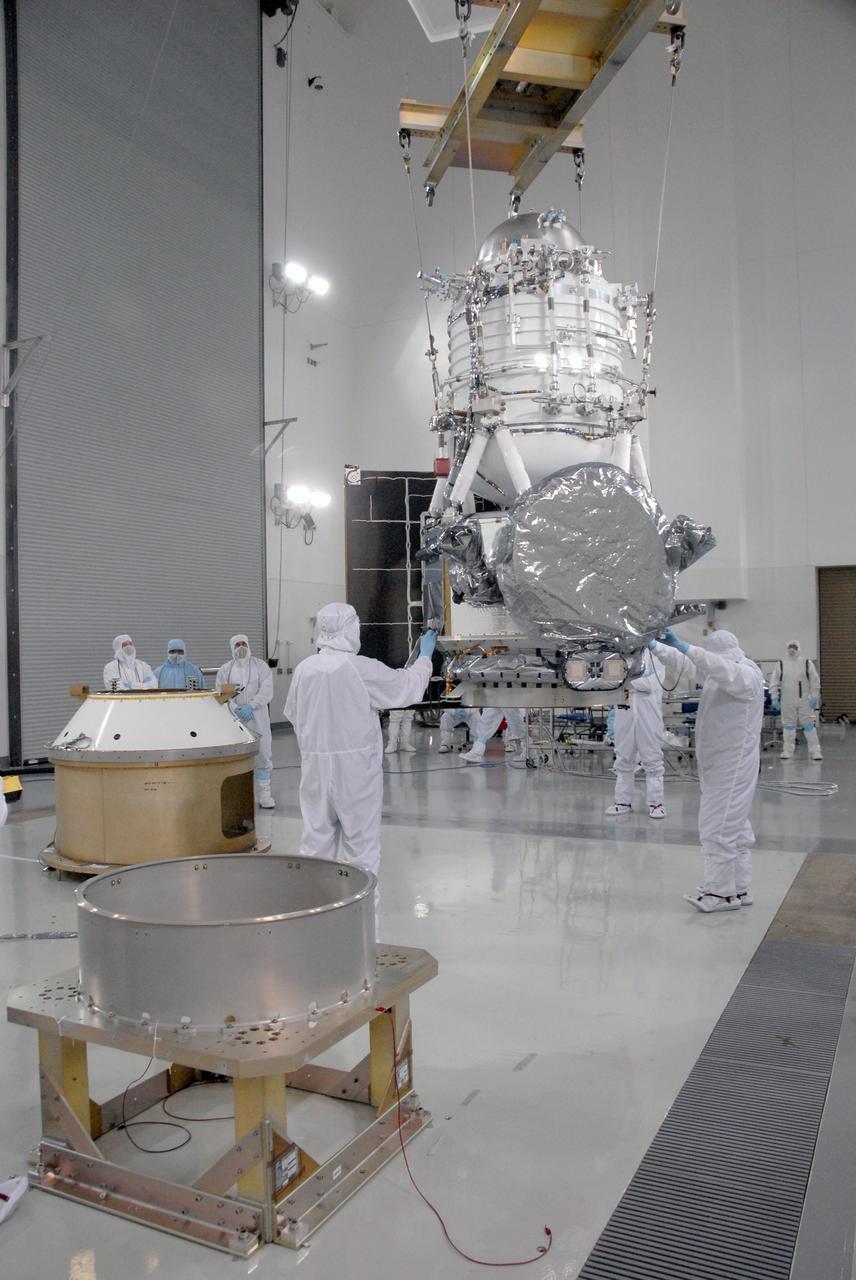 VANDENBERG AIR FORCE BASE, Calif. -- At the Astrotech processing facility on Vandenberg Air Force Base in California, workers guide NASA's Wide-field Infrared Survey Explorer, or WISE, being lifted by crane from its test stand for mating to its Payload Attach Fitting, in the background at left.    The satellite will survey the entire sky at infrared wavelengths, creating a cosmic clearinghouse of hundreds of millions of objects which will be catalogued and provide a vast storehouse of knowledge about the solar system, the Milky Way, and the universe. Launch is scheduled for Dec. 7.  Photo credit: NASA/Doug Kolkow