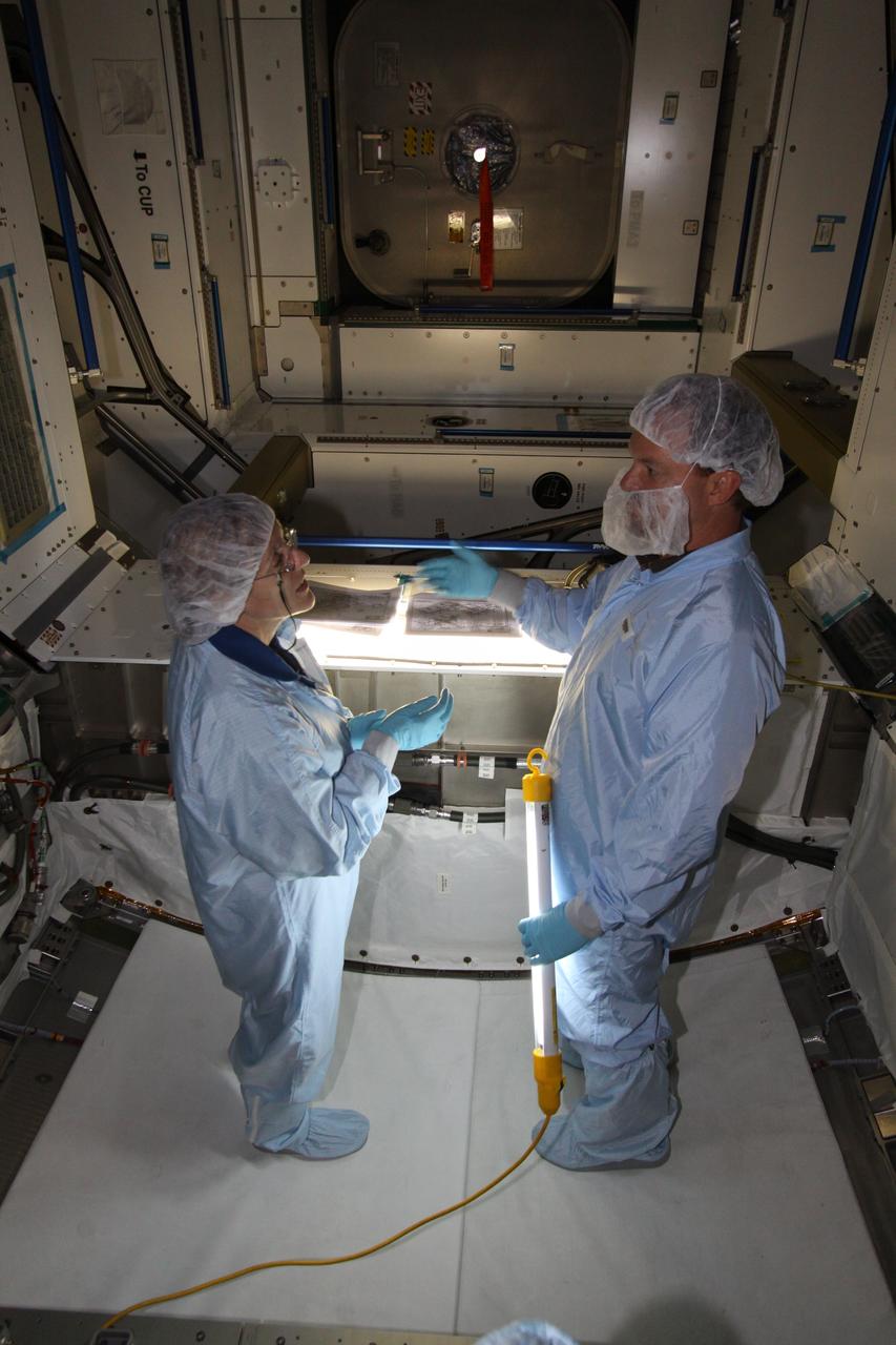 CAPE CANAVERAL, Fla. – Mission specialist Kathryn "Kay" Hire, at left, assigned to the crew of space shuttle Endeavour's STS-130 mission, becomes familiar with the configuration of the Tranquility Node 3 module in the Space Station Processing Facility at NASA's Kennedy Space Center in Florida. Assisting her, at right, is Chris Hardcastle, an STS-130 flight crew representative with United Space Alliance.    Tranquility is a pressurized module that will provide room for many of the International Space Station's life support systems. Attached to the node is a cupola, a unique work station with six windows on its sides and one on top. Tranquility is the payload for the STS-130 mission. The module was built for the European Space Agency by Alenia Spazio in Turin, Italy. Cupola resembles a circular bay window that will provide a vastly improved view of the station's exterior. Just under 10 feet in diameter, the module will accommodate two crew members and portable workstations that can control station and robotic activities. The multi-directional view will allow the crew to monitor spacewalks and docking operations, as well as provide a spectacular view of Earth and other celestial objects. Endeavour is targeted to launch Feb. 4, 2010. Photo credit: NASA/Jack Pfaller
