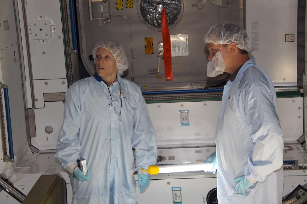CAPE CANAVERAL, Fla. – Mission specialist Kathryn "Kay" Hire, at left, a crew member on space shuttle Endeavour's STS-130 mission, photographs the interior of the Tranquility Node 3 module in the Space Station Processing Facility at NASA's Kennedy Space Center in Florida. Assisting her, at right, is Chris Hardcastle, an STS-130 flight crew representative with United Space Alliance.    Tranquility is a pressurized module that will provide room for many of the International Space Station's life support systems. Attached to the node is a cupola, a unique work station with six windows on its sides and one on top. Tranquility is the payload for the STS-130 mission. The module was built for the European Space Agency by Alenia Spazio in Turin, Italy. Cupola resembles a circular bay window that will provide a vastly improved view of the station's exterior. Just under 10 feet in diameter, the module will accommodate two crew members and portable workstations that can control station and robotic activities. The multi-directional view will allow the crew to monitor spacewalks and docking operations, as well as provide a spectacular view of Earth and other celestial objects. Endeavour is targeted to launch Feb. 4, 2010. Photo credit: NASA/Jack Pfaller