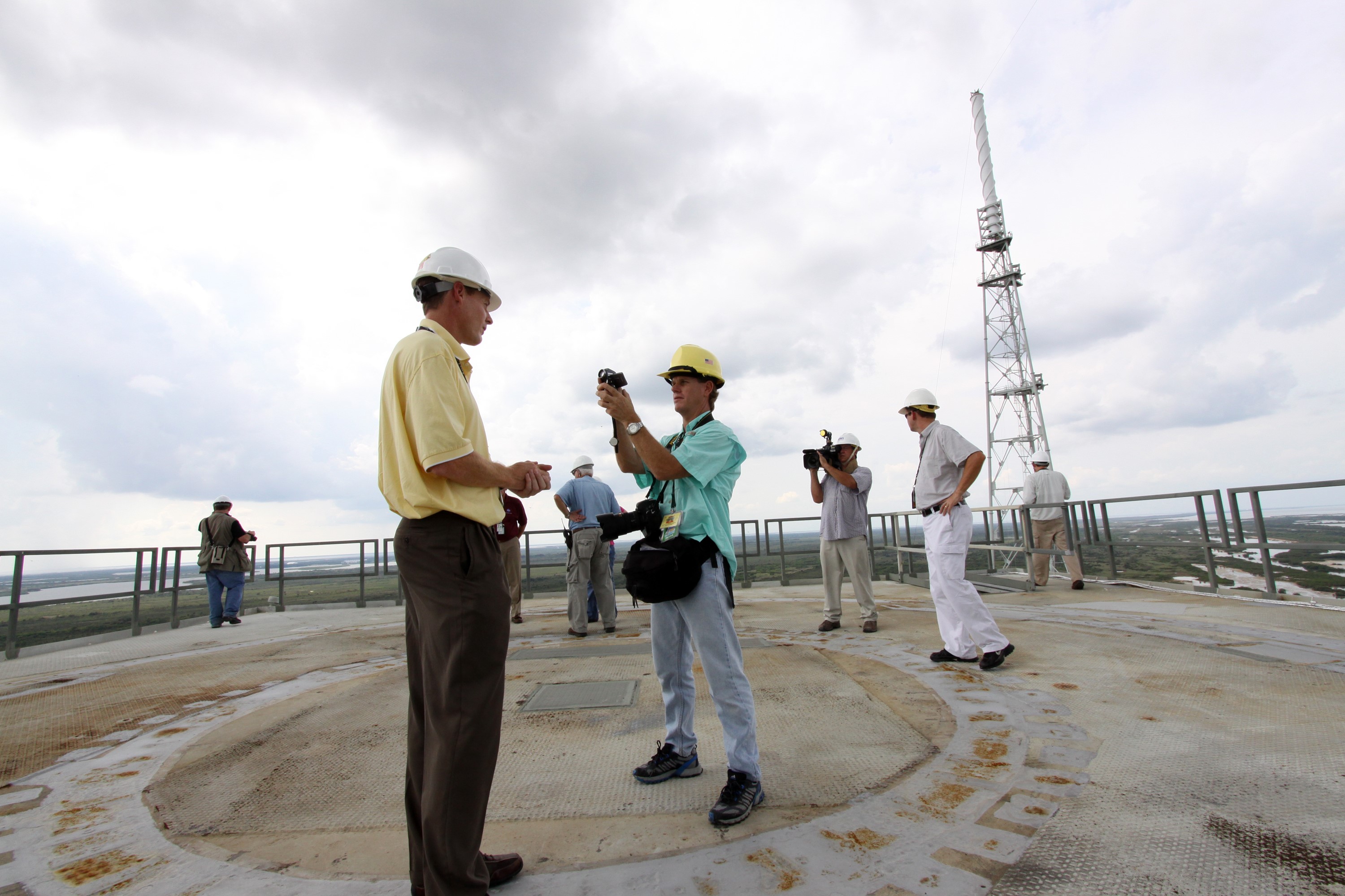CAPE CANAVERAL, Fla. – At NASA's Kennedy Space Center in Florida, Ares I-X ground systems project manager Mike Stelzer is interviewed by a member of the news media on the 295-foot level of Launch Pad 39B. Modifications to the pad to support the Ares I-X rocket are complete. The transfer of the pad from the Space Shuttle Program to the Constellation Program took place May 31. Modifications made to the pad include the removal of shuttle unique subsystems, such as the orbiter access arm and a section of the gaseous oxygen vent arm, along with the installation of three 600-foot lightning towers, access platforms, environmental control systems and a vehicle stabilization system. Part of the Constellation Program, the Ares I-X is the test vehicle for the Ares I, which is the essential core of a space transportation system designed to carry crewed missions back to the moon, on to Mars and out into the solar system. The Ares I-X flight test is targeted for Oct. 27. For information on the Ares I-X vehicle and flight test, visit http://www.nasa.gov/aresIX. Photo credit: NASA/Jack Pfaller