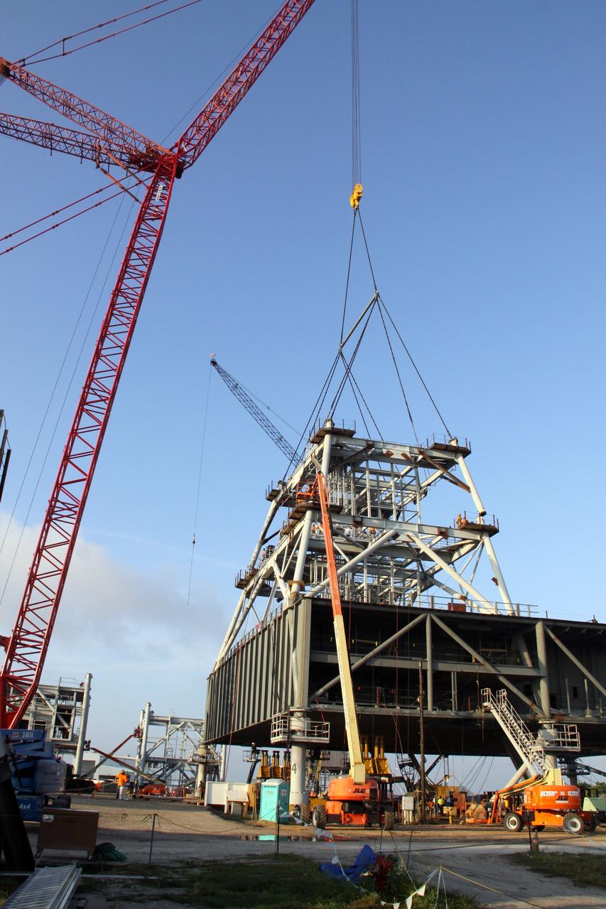 CAPE CANAVERAL, Fla. – At NASA's Kennedy Space Center in Florida, progress continues on the construction of a new mobile launcher, or ML, for the Constellation Program as a crane lowers the second section of the launcher's tower into place. Installation of the first section was on Sept. 24. The tower will have multiple platforms for personnel access and be approximately 345 feet tall. The launcher is being built at the mobile launcher park site area located north of Kennedy's Vehicle Assembly Building to support the Ares I rocket. The ML will provide a base to launch the Ares I which will transport the Orion crew exploration vehicle, its crew and cargo to low Earth orbit. The base is being made lighter than space shuttle mobile launcher platforms so the crawler-transporter can pick up the heavier load of the tower and taller rocket. For information on the Ares I, visit http://www.nasa.gov/ares. Photo credit: NASA/Jack Pfaller