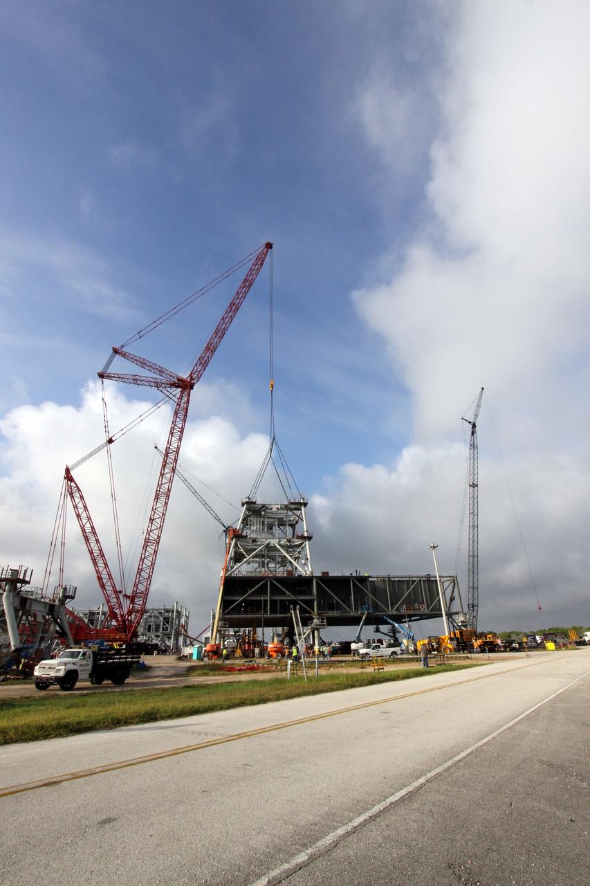 CAPE CANAVERAL, Fla. – At NASA's Kennedy Space Center in Florida, cranes support the placement of the second section of a tower for a new mobile launcher, or ML, for the Constellation Program onto the first. Installation of the first section was on Sept. 24. The tower will have multiple platforms for personnel access and be approximately 345 feet tall. The launcher is being built at the mobile launcher park site area located north of Kennedy's Vehicle Assembly Building to support the Ares I rocket. The ML will provide a base to launch the Ares I which will transport the Orion crew exploration vehicle, its crew and cargo to low Earth orbit. The base is being made lighter than space shuttle mobile launcher platforms so the crawler-transporter can pick up the heavier load of the tower and taller rocket. For information on the Ares I, visit http://www.nasa.gov/ares. Photo credit: NASA/Jack Pfaller