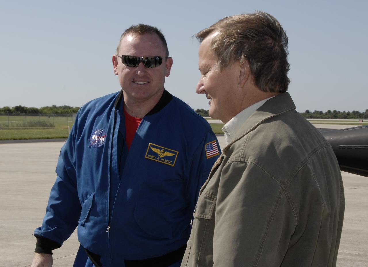 CAPE CANAVERAL, Fla. - STS-129 Pilot Barry E. Wilmore, at left, talks with STS-129 Launch Director Mike Leinbach at the Shuttle Landing Facility at NASA's Kennedy Space Center in Florida.  The crew members of space shuttle Atlantis' STS-129 mission have arrived at Kennedy for training related to their launch dress rehearsal, the Terminal Countdown Demonstration Test.    Launch of Atlantis on its STS-129 mission to the International Space Station is targeted for November. For information on the STS-129 mission objectives and crew, visit http://www.nasa.gov/mission_pages/shuttle/shuttlemissions/sts129/index.html. Photo credit: NASA/Kim Shiflett
