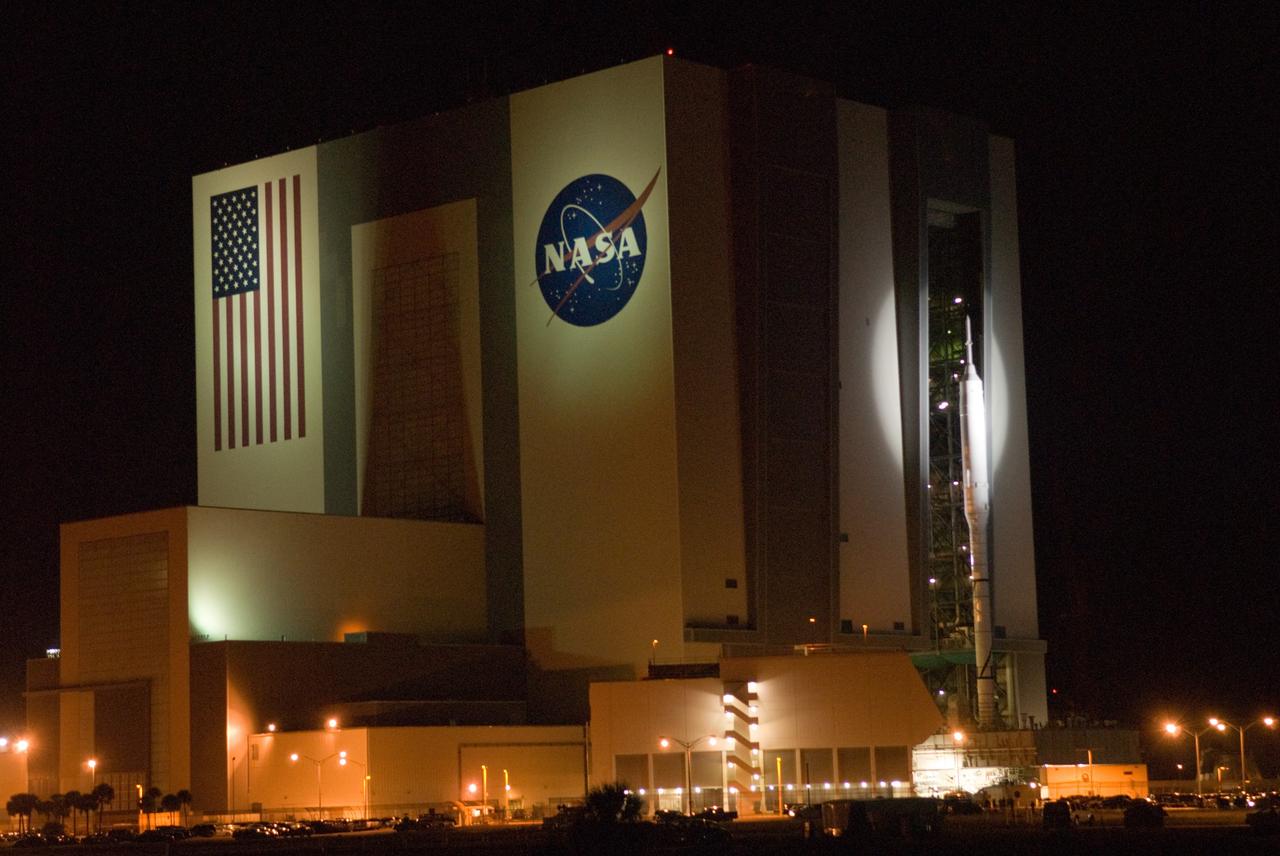 CAPE CANAVERAL, Fla. – Spotlighted against the Vehicle Assembly Building at NASA's Kennedy Space Center in Florida, the 327-foot-tall Ares I-X rocket begins its slow trek to Launch Pad 39B. The move, known as "rollout," began at 1:39 a.m. EDT. The transfer of the pad from the Space Shuttle Program to the Constellation Program took place May 31. Modifications made to the pad include the removal of shuttle unique subsystems, such as the orbiter access arm and a section of the gaseous oxygen vent arm, along with the installation of three 600-foot lightning towers, access platforms, environmental control systems and a vehicle stabilization system. Part of the Constellation Program, the Ares I-X is the test vehicle for the Ares I. The Ares I-X flight test is targeted for Oct. 27. For information on the Ares I-X vehicle and flight test, visit http://www.nasa.gov/aresIX. Photo credit: NASA/Jim Grossmann