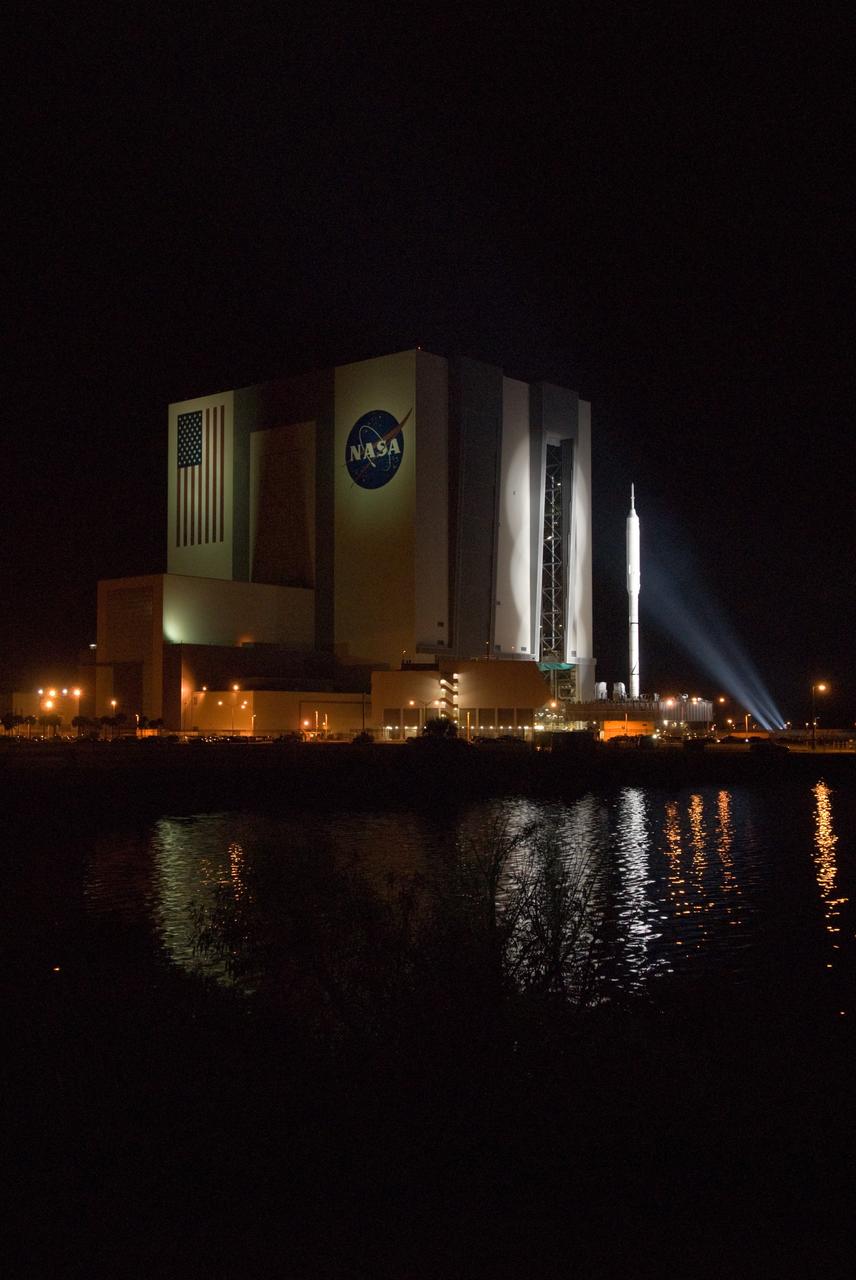 CAPE CANAVERAL, Fla. – Reflected in the water of the turn basin near the Vehicle Assembly Building at NASA's Kennedy Space Center in Florida, the 327-foot-tall Ares I-X rocket begins its slow trek to Launch Pad 39B. The move, known as "rollout," began at 1:39 a.m. EDT. The transfer of the pad from the Space Shuttle Program to the Constellation Program took place May 31. Modifications made to the pad include the removal of shuttle unique subsystems, such as the orbiter access arm and a section of the gaseous oxygen vent arm, along with the installation of three 600-foot lightning towers, access platforms, environmental control systems and a vehicle stabilization system.  Part of the Constellation Program, the Ares I-X is the test vehicle for the Ares I. The Ares I-X flight test is targeted for Oct. 27. For information on the Ares I-X vehicle and flight test, visit http://www.nasa.gov/aresIX. Photo credit: NASA/Jim Grossmann