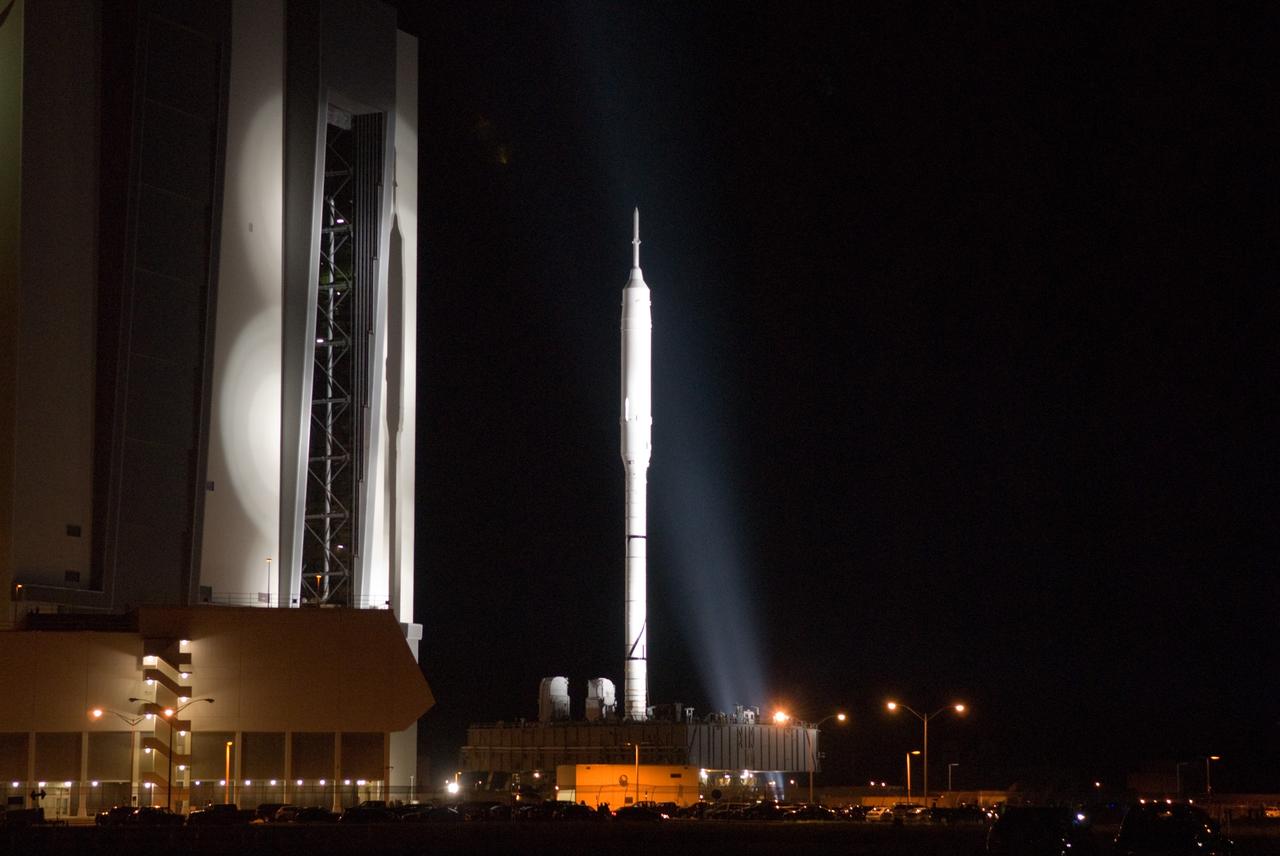 CAPE CANAVERAL, Fla. – Standing tall, the Ares I-X rocket rides atop the crawler-transporter as it moves beyond the Vehicle Assembly Building at NASA's Kennedy Space Center in Florida. Its slow trek to Launch Pad 39B, known as "rollout," began at 1:39 a.m. EDT. The transfer of the pad from the Space Shuttle Program to the Constellation Program took place May 31. Modifications made to the pad include the removal of shuttle unique subsystems, such as the orbiter access arm and a section of the gaseous oxygen vent arm, along with the installation of three 600-foot lightning towers, access platforms, environmental control systems and a vehicle stabilization system. Part of the Constellation Program, the Ares I-X is the test vehicle for the Ares I. The Ares I-X flight test is targeted for Oct. 27. For information on the Ares I-X vehicle and flight test, visit http://www.nasa.gov/aresIX. Photo credit: NASA/Jim Grossmann