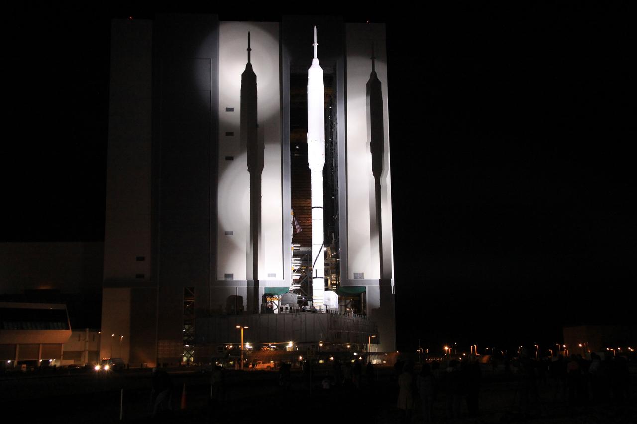 CAPE CANAVERAL, Fla. – The 327-foot-tall Ares I-X rocket casts shadows on the massive Vehicle Assembly Building at NASA's Kennedy Space Center in Florida as it heads to Launch Pad 39B aboard a crawler-transporter. The move to the launch pad, known as "rollout," began at 1:39 a.m. EDT. The transfer of the pad from the Space Shuttle Program to the Constellation Program took place May 31. Modifications made to the pad include the removal of shuttle unique subsystems, such as the orbiter access arm and a section of the gaseous oxygen vent arm, along with the installation of three 600-foot lightning towers, access platforms, environmental control systems and a vehicle stabilization system. Part of the Constellation Program, the Ares I-X is the test vehicle for the Ares I. The Ares I-X flight test is targeted for Oct. 27. For information on the Ares I-X vehicle and flight test, visit http://www.nasa.gov/aresIX. Photo credit: NASA/Jack Pfaller