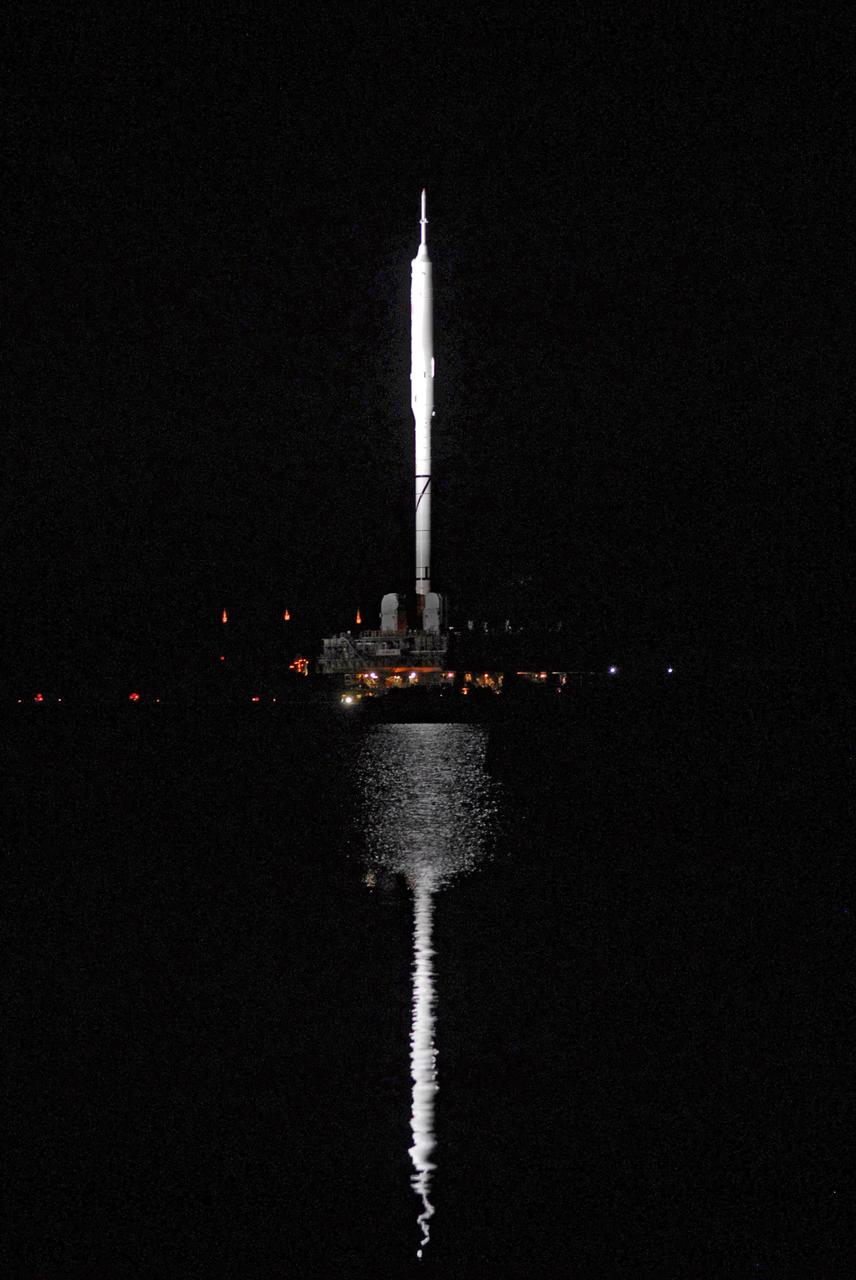 CAPE CANAVERAL, Fla. - The towering 327-foot-tall Ares I-X rocket is strikingly reflected in the waters of the turn basin at NASA's Kennedy Space Center in Florida. The rocket, riding atop a crawler-transporter, is headed for Launch Pad 39B. The move to the launch pad, known as "rollout," began at 1:39 a.m. EDT.    The transfer of the pad from the Space Shuttle Program to the Constellation Program took place May 31. Modifications made to the pad include the removal of shuttle unique subsystems, such as the orbiter access arm and a section of the gaseous oxygen vent arm, along with the installation of three 600-foot lightning towers, access platforms, environmental control systems and a vehicle stabilization system.  Part of the Constellation Program, the Ares I-X is the test vehicle for the Ares I. The Ares I-X flight test is targeted for Oct. 27. For information on the Ares I-X vehicle and flight test, visit http://www.nasa.gov/aresIX. Photo credit: NASA/Jim Grossman