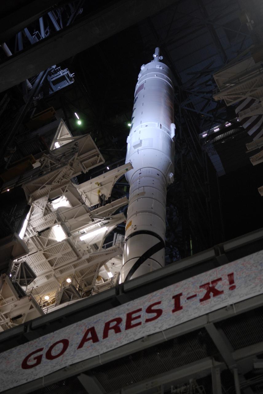 CAPE CANAVERAL, Fla. - Inside the Vehicle Assembly Building at NASA's Kennedy Space Center in Florida, the 327-foot-tall Ares I-X rocket stands on the mobile launcher platform with a "Go Ares I-X" banner. The work platforms surrounding the rocket are in the process of being retracted prior to rollout to Launch Pad 39B.    The transfer of the pad from the Space Shuttle Program to the Constellation Program took place May 31. Modifications made to the pad include the removal of shuttle unique subsystems, such as the orbiter access arm and a section of the gaseous oxygen vent arm, along with the installation of three 600-foot lightning towers, access platforms, environmental control systems and a vehicle stabilization system.  Part of the Constellation Program, the Ares I-X is the test vehicle for the Ares I. The Ares I-X flight test is targeted for Oct. 27. For information on the Ares I-X vehicle and flight test, visit http://www.nasa.gov/aresIX. Photo credit: NASA/Kim Shiflett