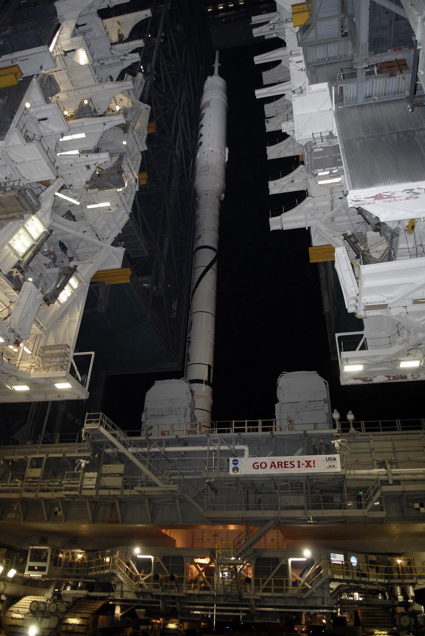 CAPE CANAVERAL, Fla. - The crawler-transporter is positioned under the mobile launcher platform with the 327-foot-tall Ares I-X rocket. The rocket is prepared to leave the Vehicle Assembly Building at NASA's Kennedy Space Center in Florida, on its way to Launch Pad 39B. The move to the launch pad, known as "rollout," began at 1:39 a.m. EDT.    The transfer of the pad from the Space Shuttle Program to the Constellation Program took place May 31. Modifications made to the pad include the removal of shuttle unique subsystems, such as the orbiter access arm and a section of the gaseous oxygen vent arm, along with the installation of three 600-foot lightning towers, access platforms, environmental control systems and a vehicle stabilization system.  Part of the Constellation Program, the Ares I-X is the test vehicle for the Ares I. The Ares I-X flight test is targeted for Oct. 27. For information on the Ares I-X vehicle and flight test, visit http://www.nasa.gov/aresIX. Photo credit: NASA/Kim Shiflett