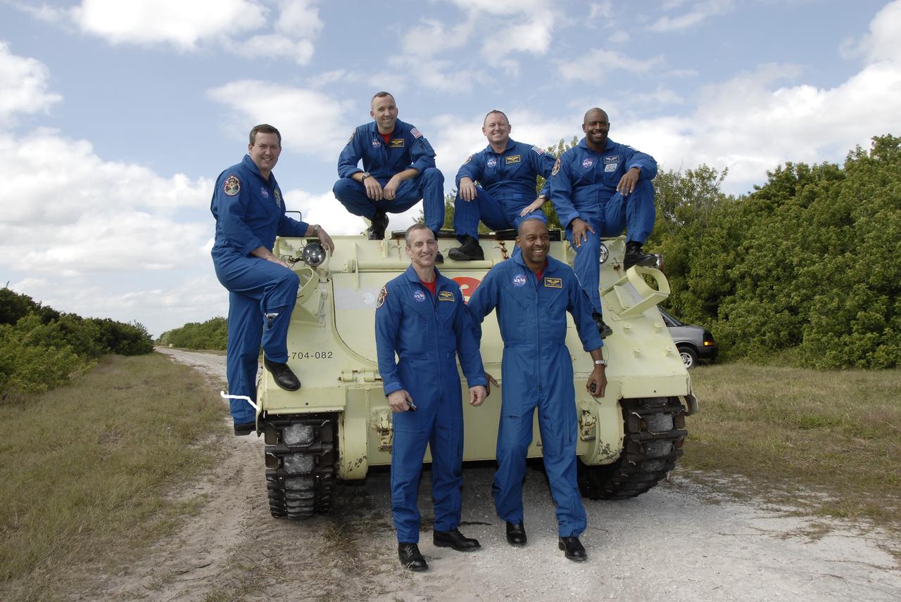 CAPE CANAVERAL, Fla. - At NASA's Kennedy Space Center in Florida, the STS-129 crew poses for a group portrait with the M113 armored personnel carrier which they each practiced driving.  From left, on the ground, are Commander Charles O. Hobaugh and Mission Specialist Robert L. Satcher Jr.  From left, on the M113, are Mission Specialists Mike Foreman and Randy Bresnik, Pilot Barry E. Wilmore and Mission Specialist Leland Melvin.    The M113 is kept at the foot of the launch pad in case an emergency egress from the vicinity of the pad is needed.  The crew members of space shuttle Atlantis' STS-129 mission are at Kennedy for training related to their launch dress rehearsal, the Terminal Countdown Demonstration Test.  Launch of Atlantis on its STS-129 mission to the International Space Station is targeted for Nov. 16. For information on the STS-129 mission objectives and crew, visit http://www.nasa.gov/mission_pages/shuttle/shuttlemissions/sts129/index.html. Photo credit: NASA/Kim Shiflett