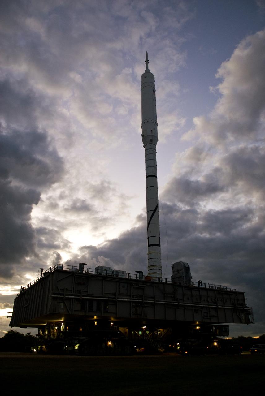 CAPE CANAVERAL, Fla. – The towering 327-foot-tall Ares I-X rocket, moved by the power of a crawler-transporter, is revealed on its 4.2-mile trip to Launch Pad 39B by the sun rising over NASA's Kennedy Space Center in Florida.    The test rocket left the Vehicle Assembly Building at 1:39 a.m. EDT on its 4.2-mile trek to the pad and was "hard down" on the pad’s pedestals at 9:17 a.m.  The transfer of the pad from the Space Shuttle Program to the Constellation Program took place May 31. Modifications made to the pad include the removal of shuttle unique subsystems, such as the orbiter access arm and a section of the gaseous oxygen vent arm, along with the installation of three 600-foot lightning towers, access platforms, environmental control systems and a vehicle stabilization system.  Part of the Constellation Program, the Ares I-X is the test vehicle for the Ares I. The Ares I-X flight test is targeted for Oct. 27. For information on the Ares I-X vehicle and flight test, visit http://www.nasa.gov/aresIX.  Photo credit: NASA/Kim Shiflett